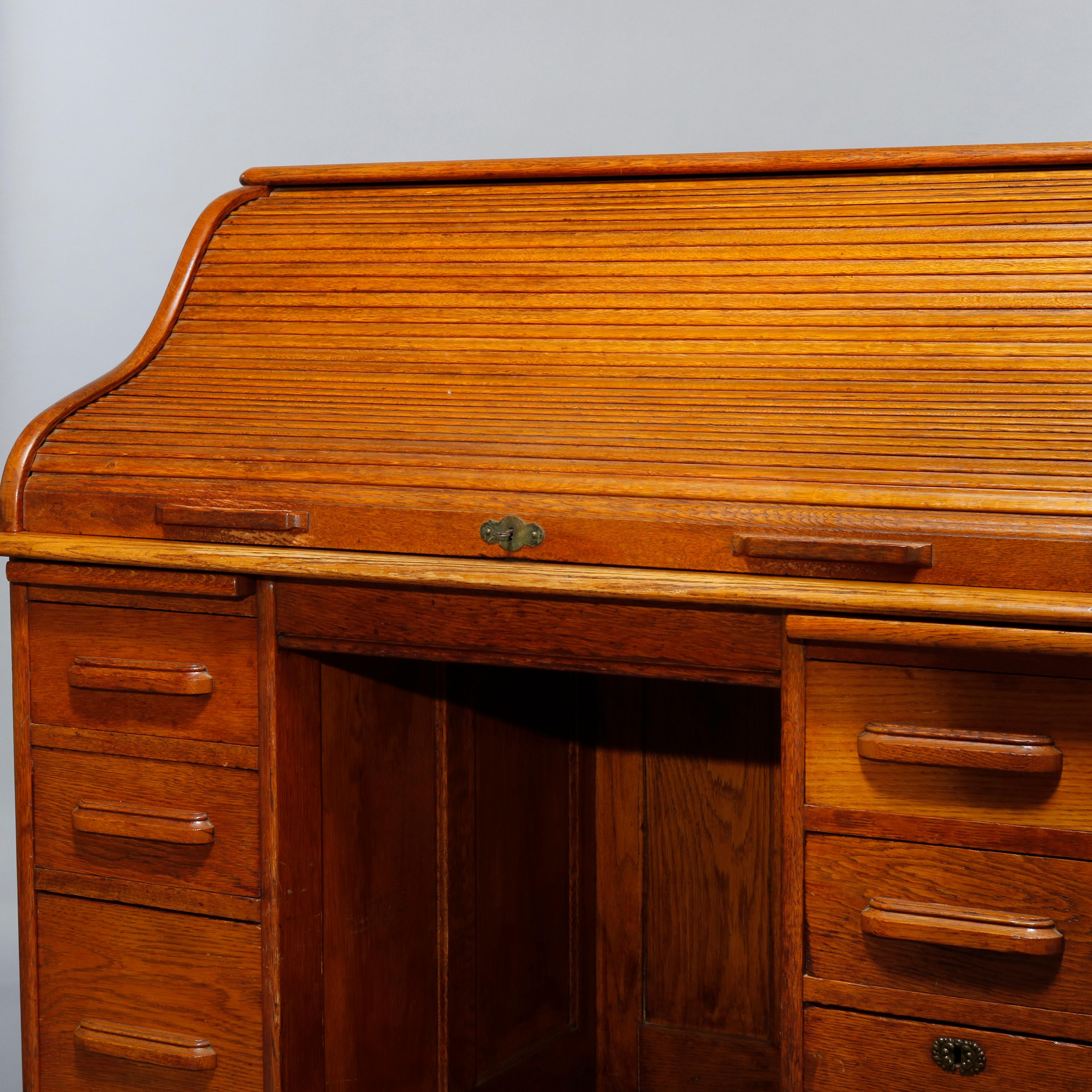 An antique roll top office desk in the manner of derby offers golden oak paneled construction with s-roll top opening to reveal writing surface and storage raised on base having double drawer tower, c1900.

Measures: 44.5