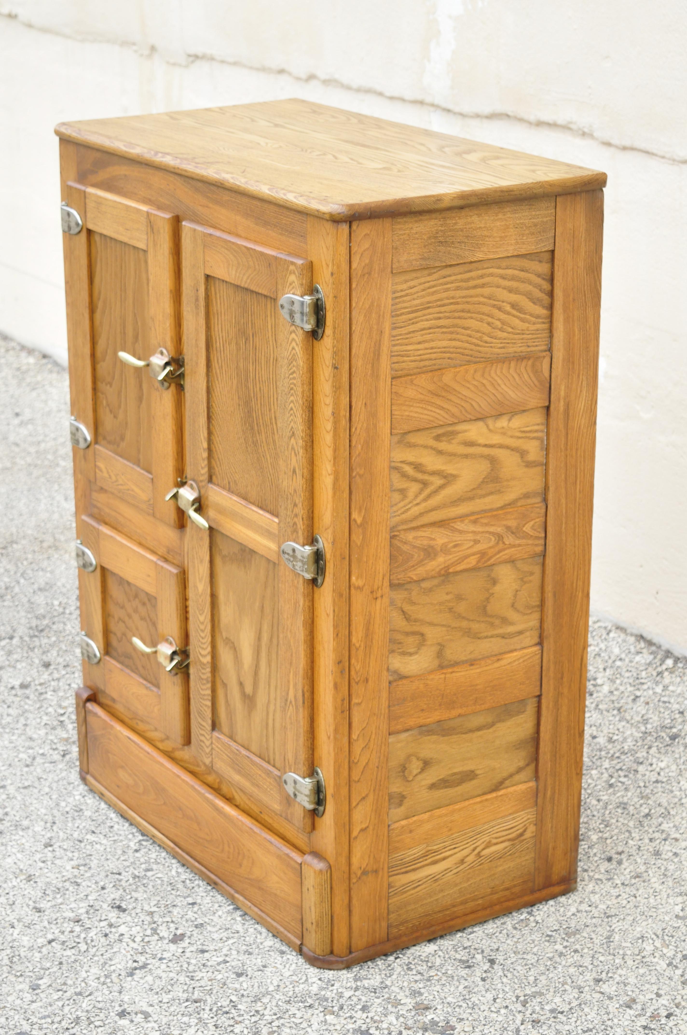 Antique golden oakwood ice box by Herrick Refrigerator Company. Item features paneled sides, beautiful wood grain, quality American craftsmanship, great style and form, circa early 1900s. Measurements: 42.5