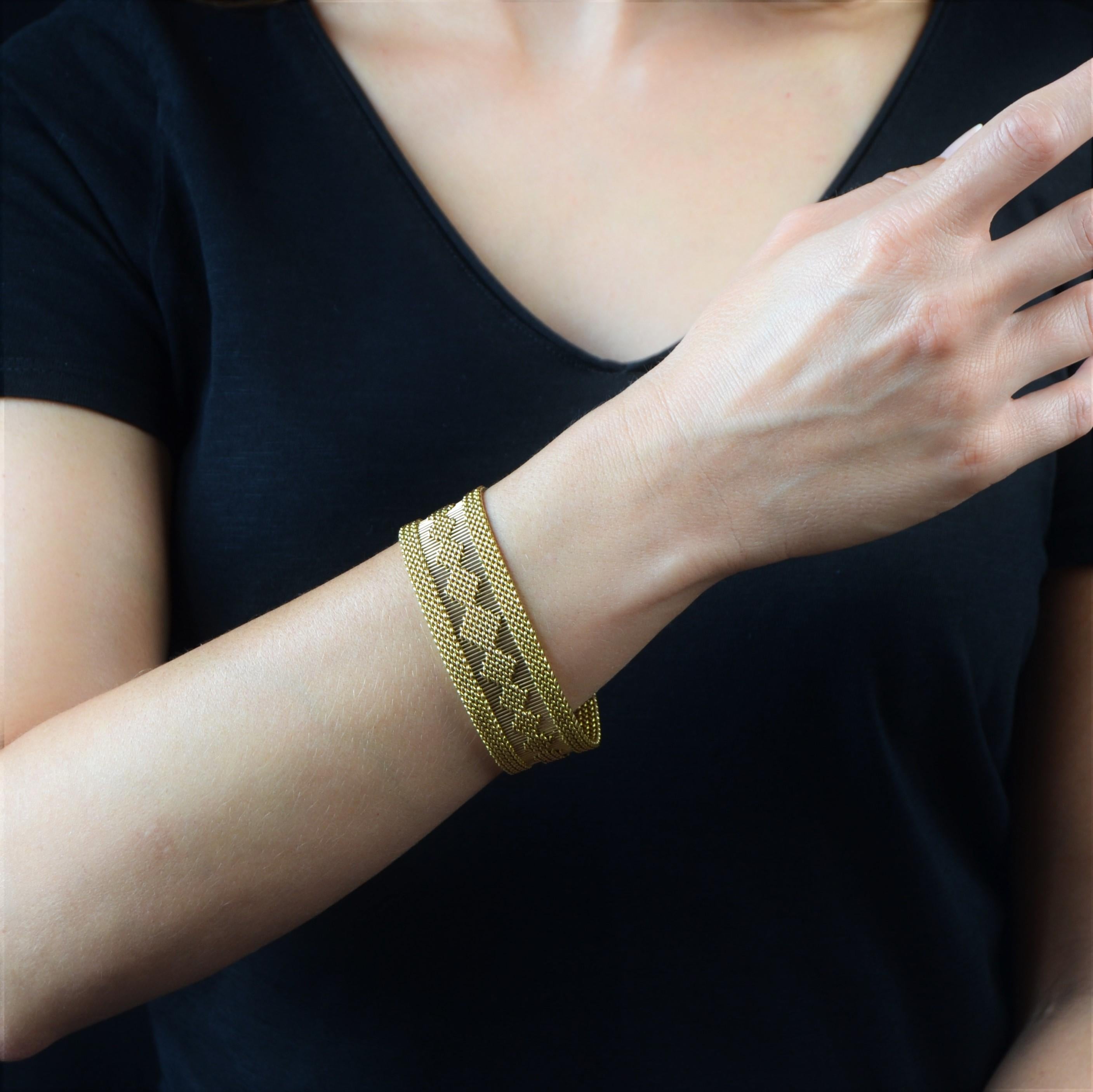 Bracelet in 18 karat yellow gold. 
This antique golden bracelet is composed of a flexible woven golden mesh with a central openwork feature. The clasp is in the form of a clip with 2 safety 8 fixtures. 
Total length : 19.4 cm, width: 2.35 cm, the