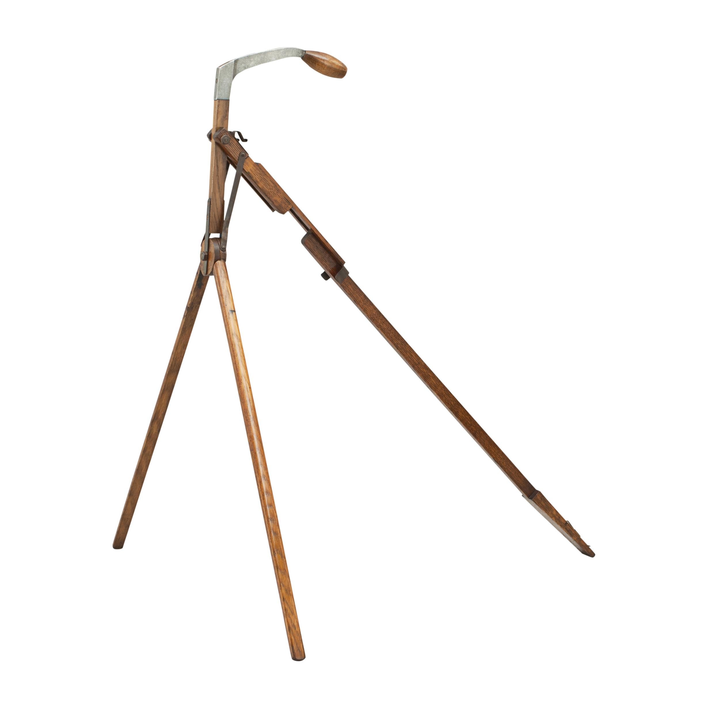 A unusual caddie stand for your pencil golf bag. Made by the English firm, F.H. Ayres, the stand clips onto your golf bag, thus turning it into a caddie bag. With the push of a handle the two oak scissor legs come out to support the bag. The