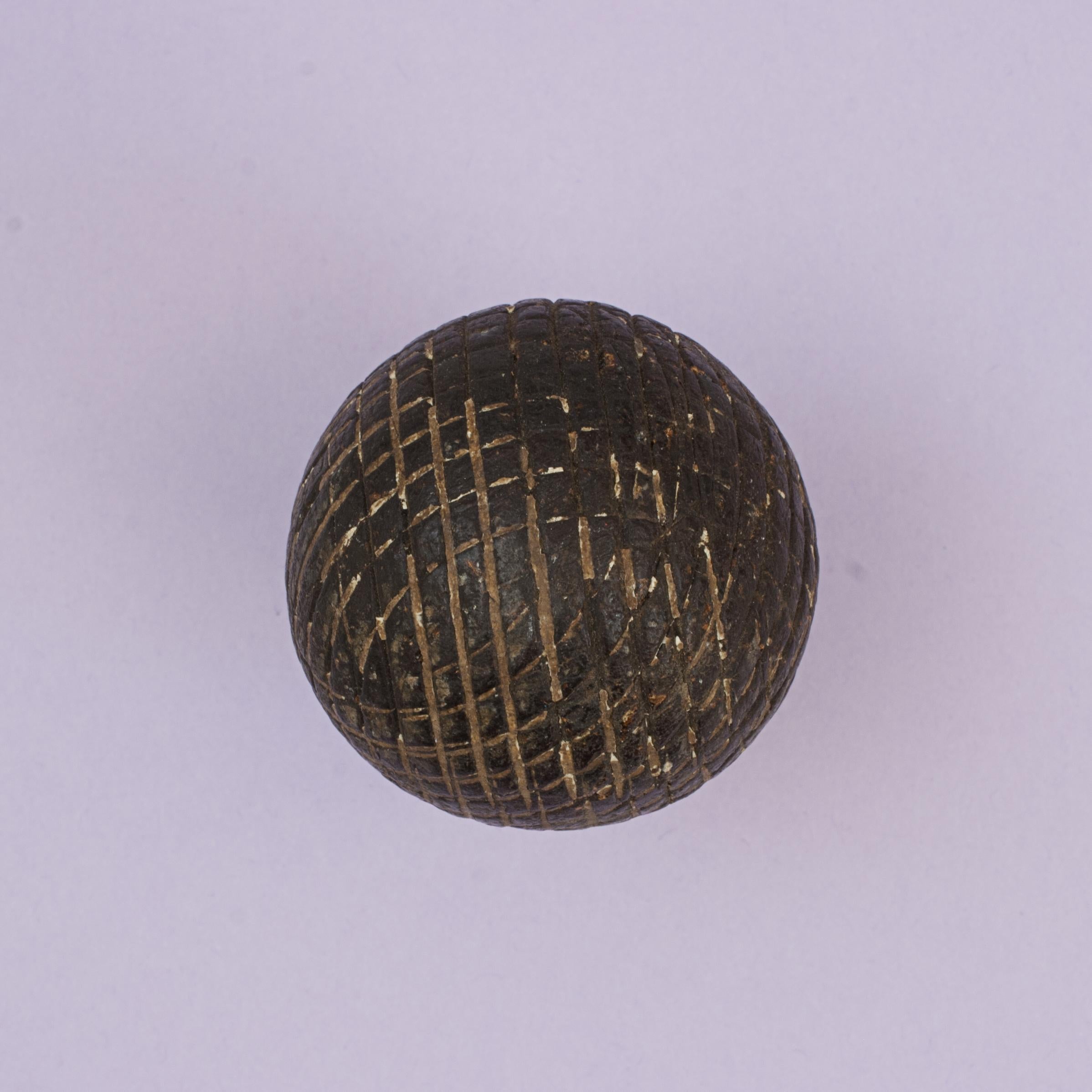 Solid Mesh Gutty Golf Ball.
A very rare solid moulded unusual diamond/square mesh pattern gutta percha golf ball in original, well used condition. The 1890's gutty ball with no name and manufacture unknown. The unusual mesh pattern of squares and