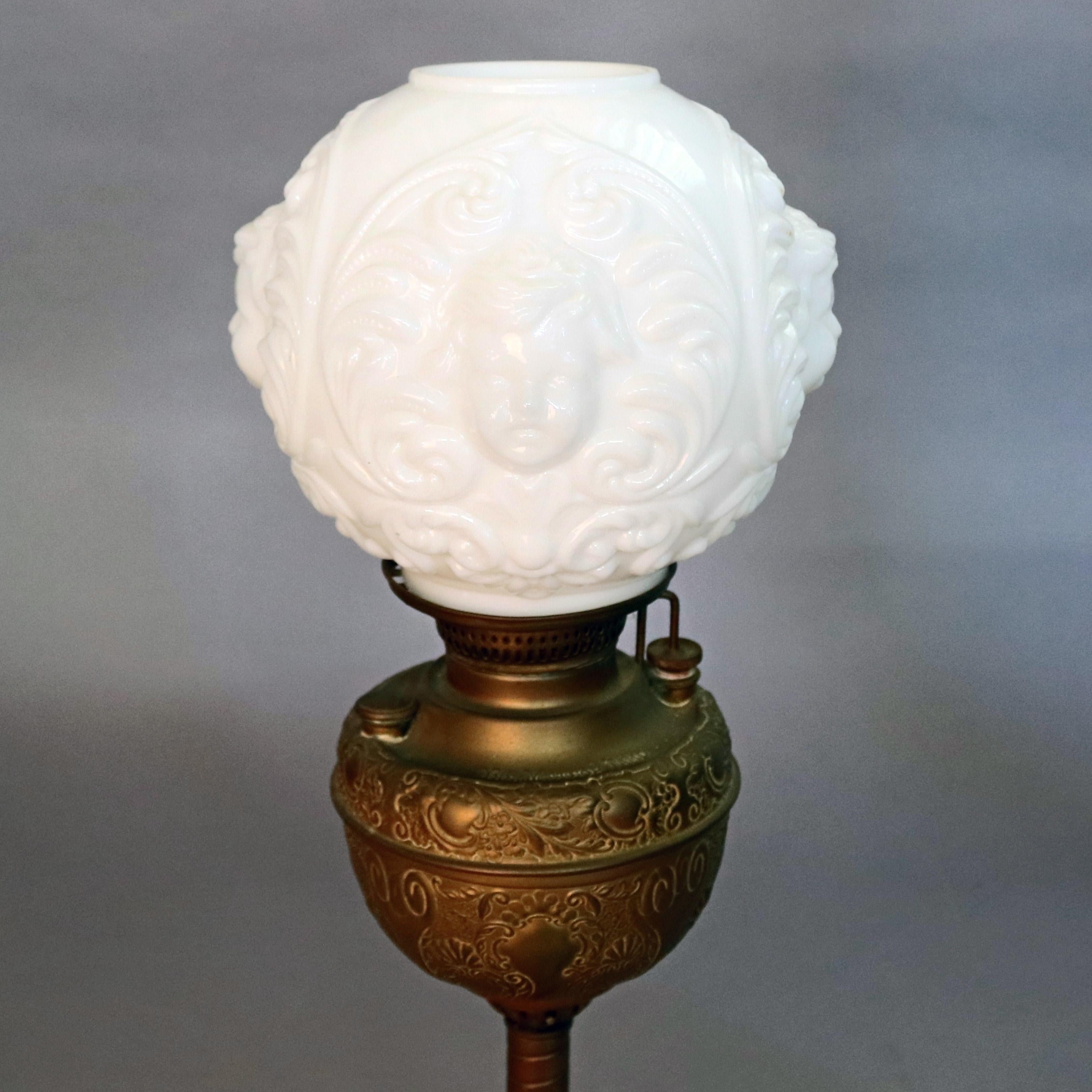 An antique Gone with the wind electrified oil lamp features scroll and foliate decorated font surmounting spiral shaft and seated on pierced foliate cast metal base and having blown out milk glass shade with cherub faces, circa 1890

Measures: