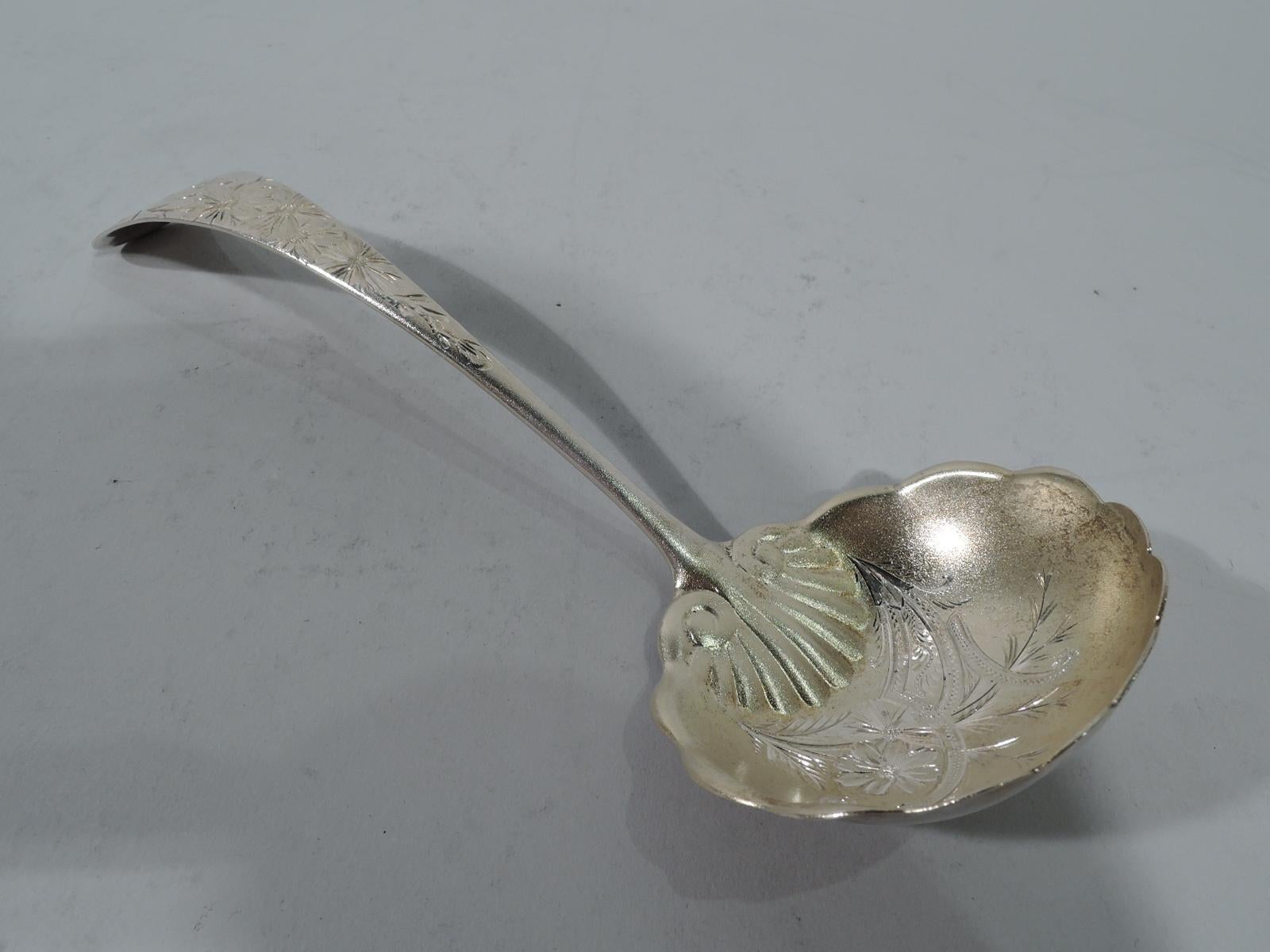 Aesthetic gilt sterling silver gravy ladle with bright-cut ornament. Made by Gorham in Providence, circa 1885. Tapering handle and scalloped bowl with chased scallop shell. Stylized flowers, foliage and scrolls. Engraved on terminal is single letter