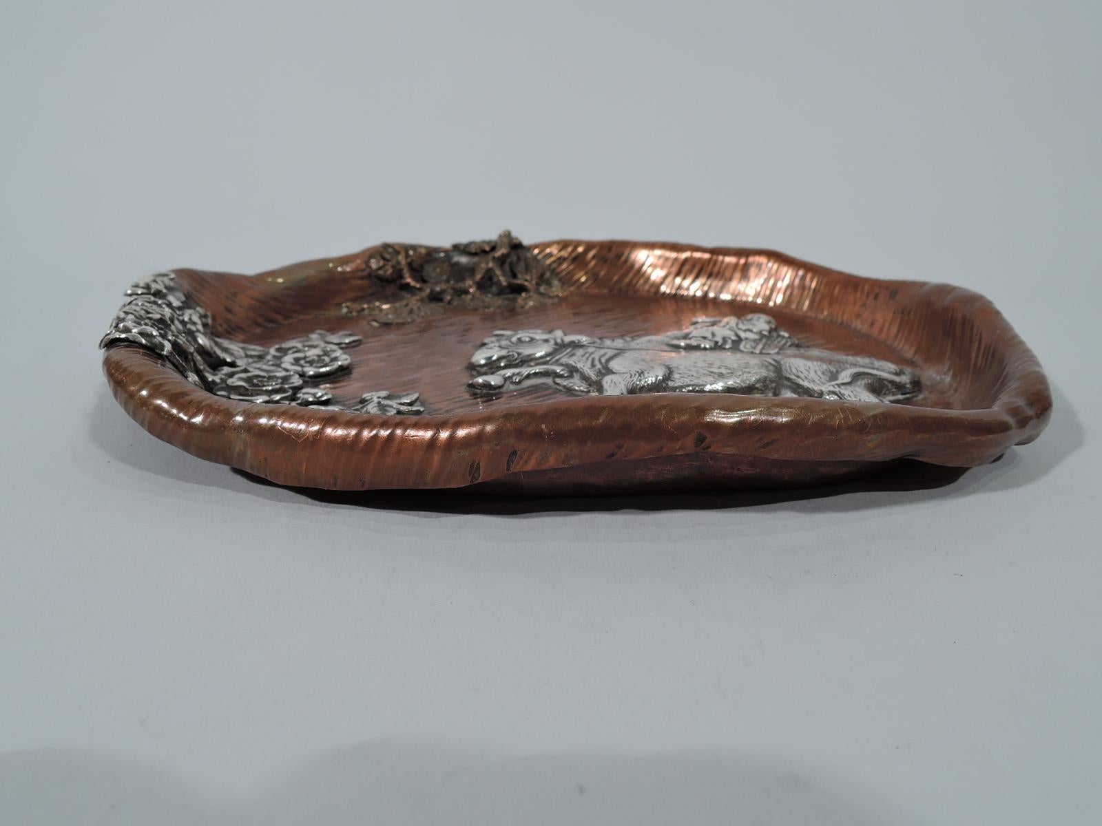 Japonesque mixed metal tray. Made by Gorham in Providence in 1882. Round with irregularly crimped turned-down rim. Striated ground. Applied silver oxen bearing a robed flautist. Blossoming prunus branch (also silver) and leafing branch (copper)