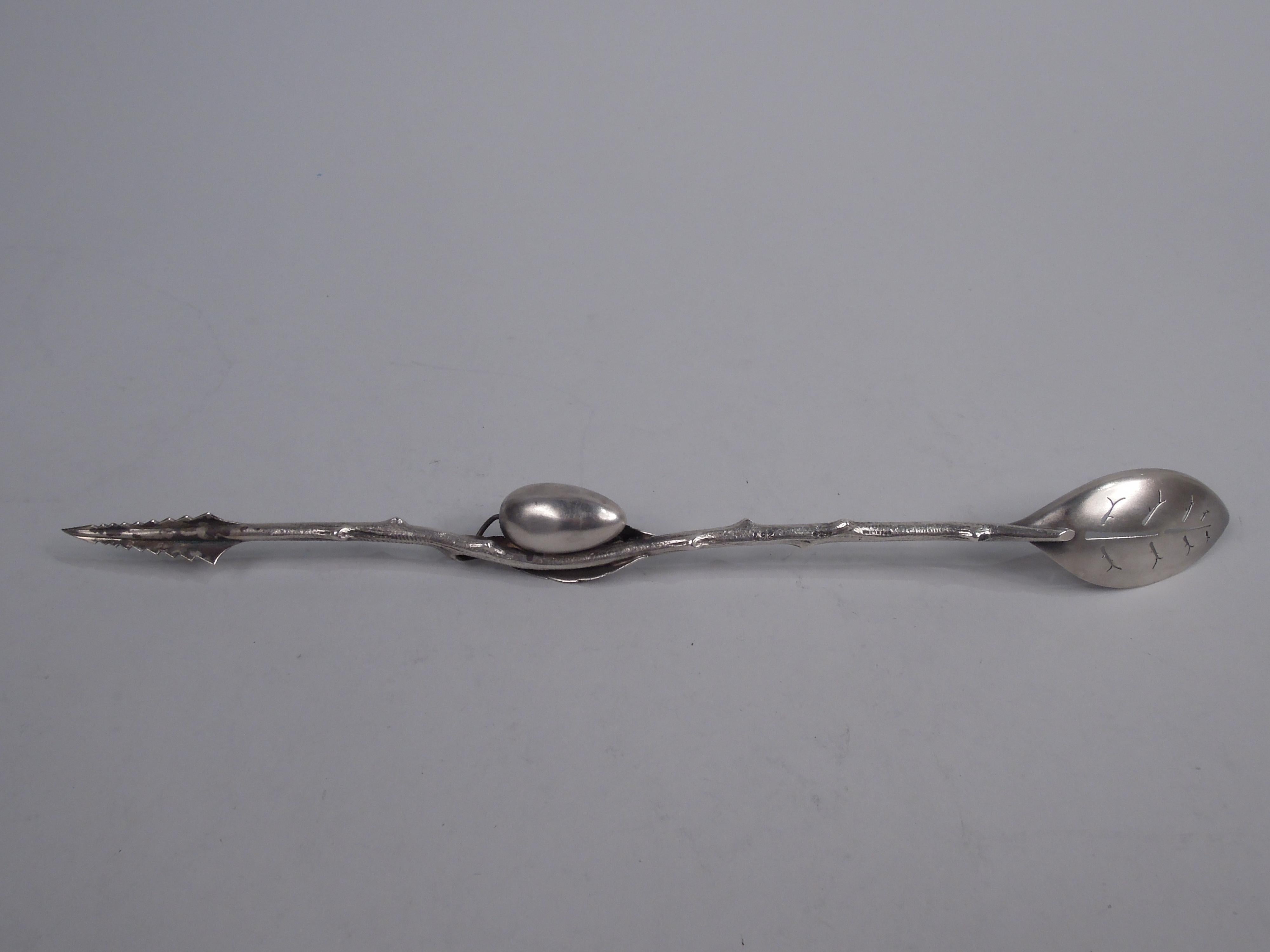 Aesthetic sterling silver olive spoon. Made by Gorham in Providence, ca 1885. Cast stem with entwined leaf and olive. Shallow and pierced bowl with engraved leaves. At other end pick comprising graduated triangles. Butler finish. Fully marked