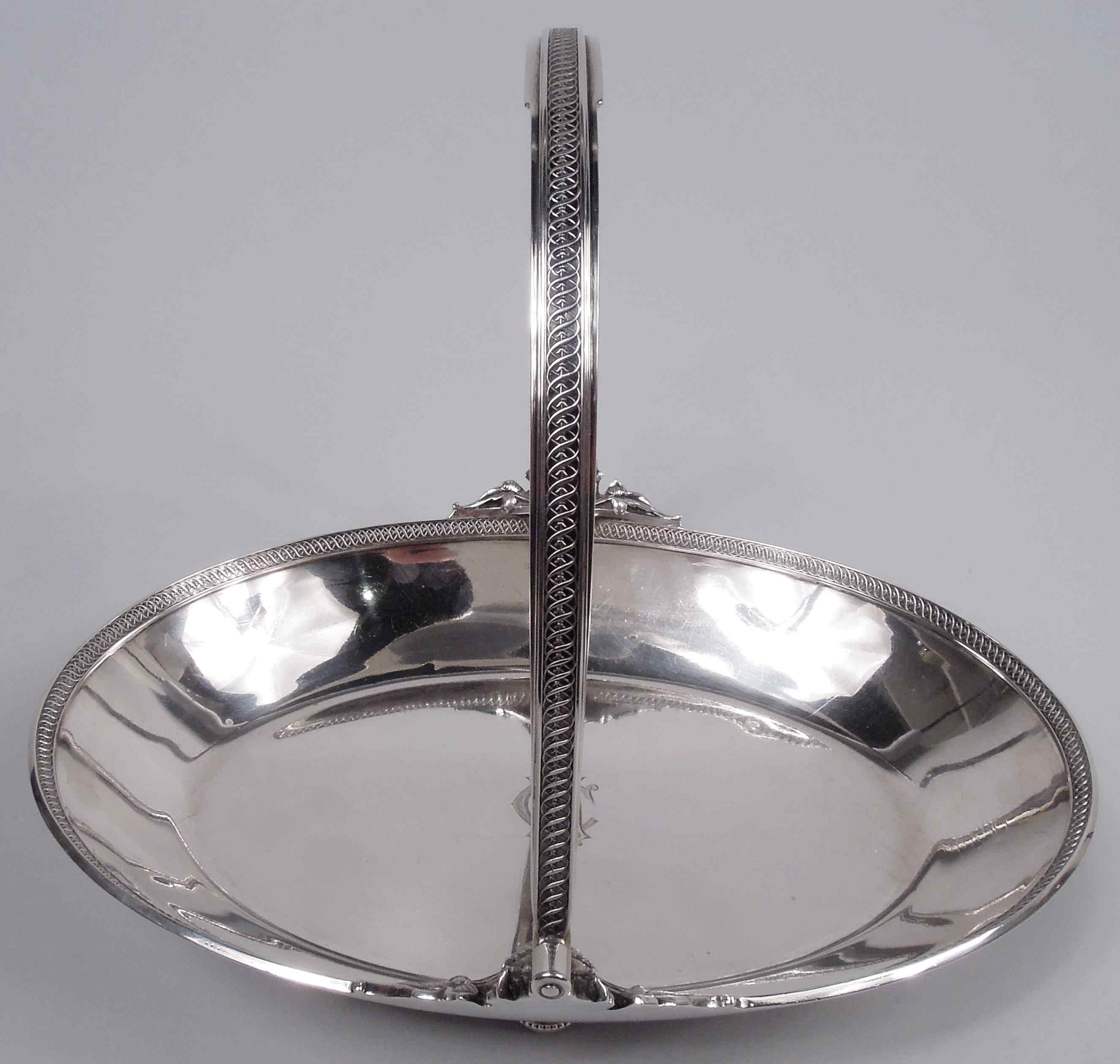 Classical coin silver basket. Made by Gorham in Providence, ca 1860. Oval with tapering sides. Rim interior has cast rinceau border threaded with leafing stem. C-scroll swing handle has same with cast mounts in form of leaf-strewn craggy and bearded