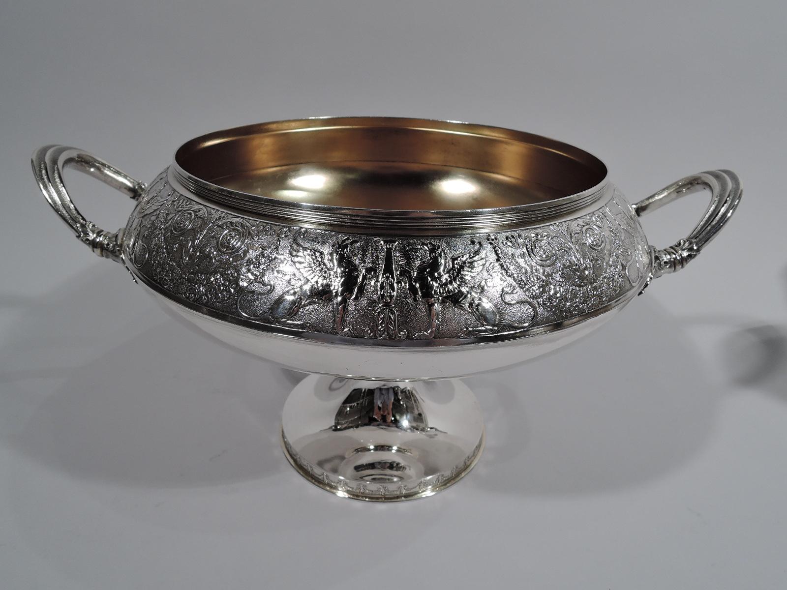 American Classical sterling silver compote. Made by Gorham in Providence in 1876. Bellied bowl with leaf-mounted c-scroll side handles and knopped stem flowing into round and raised foot. Low-relief ornament on stippled ground. Bowl has wraparound