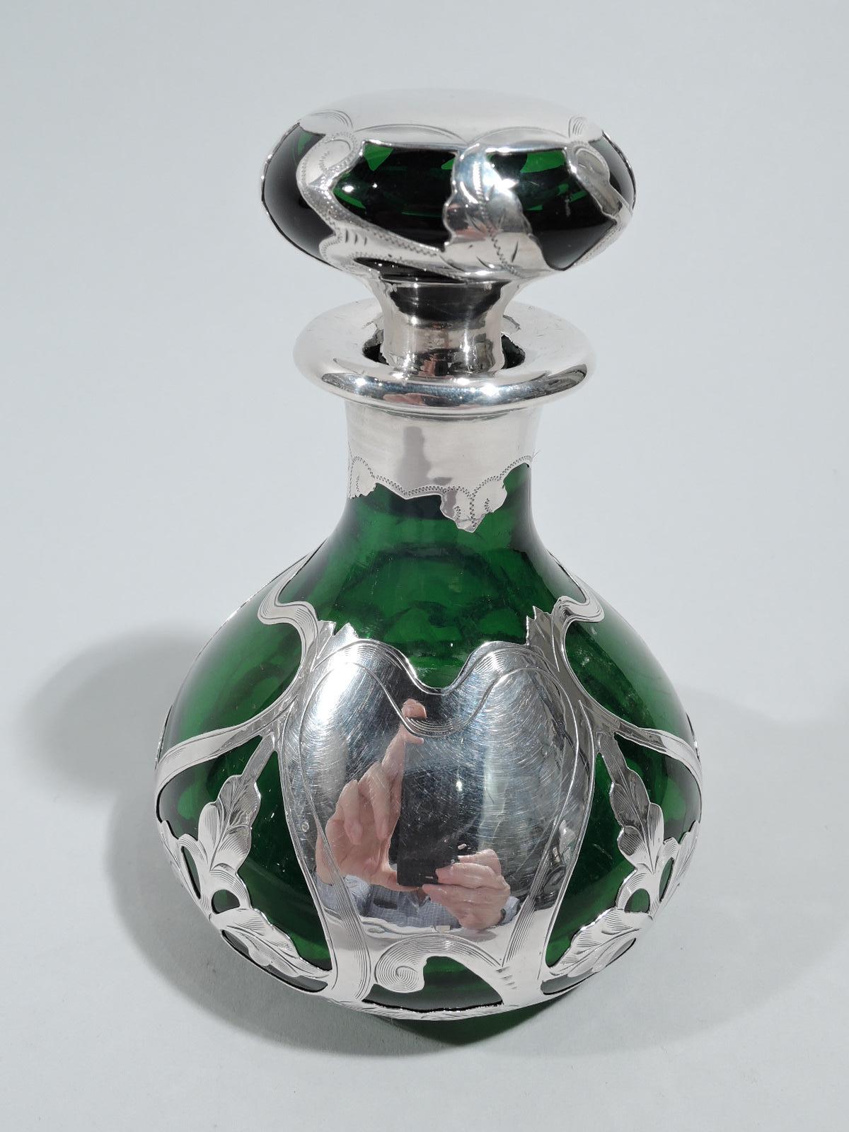 Turn-of-the-century Art Nouveau glass perfume with engraved silver overlay. Made by Gorham in Providence. Ovoid with short neck and flat rim in silver collar. Flattened ball stopper. Overlay in form of open whiplash tendril frames of which some