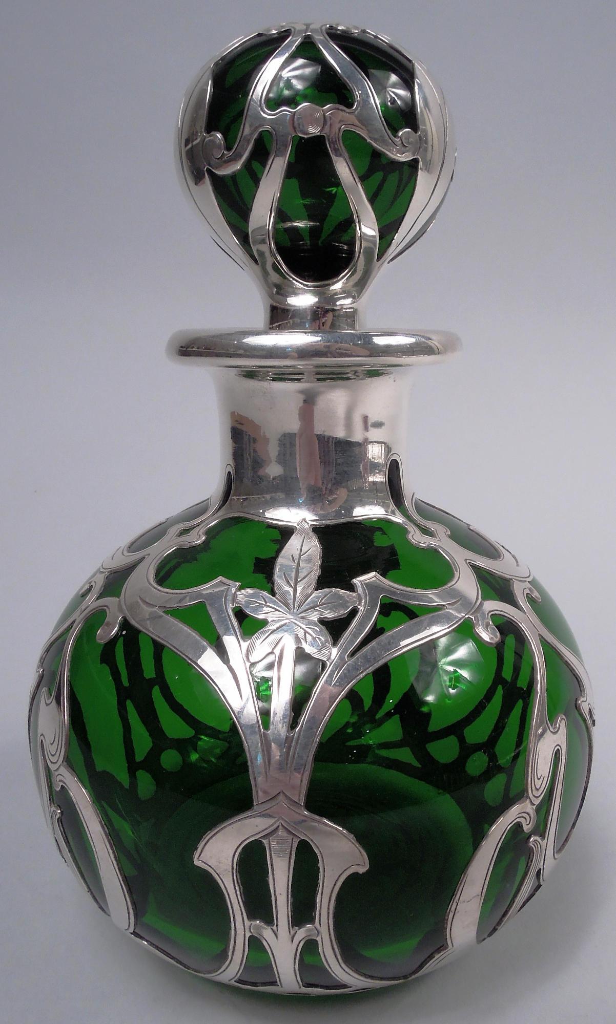 Parfum en verre de style Art Nouveau, avec revêtement en argent gravé. Fabriqué par Gorham à Providence, vers 1900. Globulaire avec un col court et un bord évasé dans un collier en argent ; bouchon en forme de boule. Superposition sous forme de coup