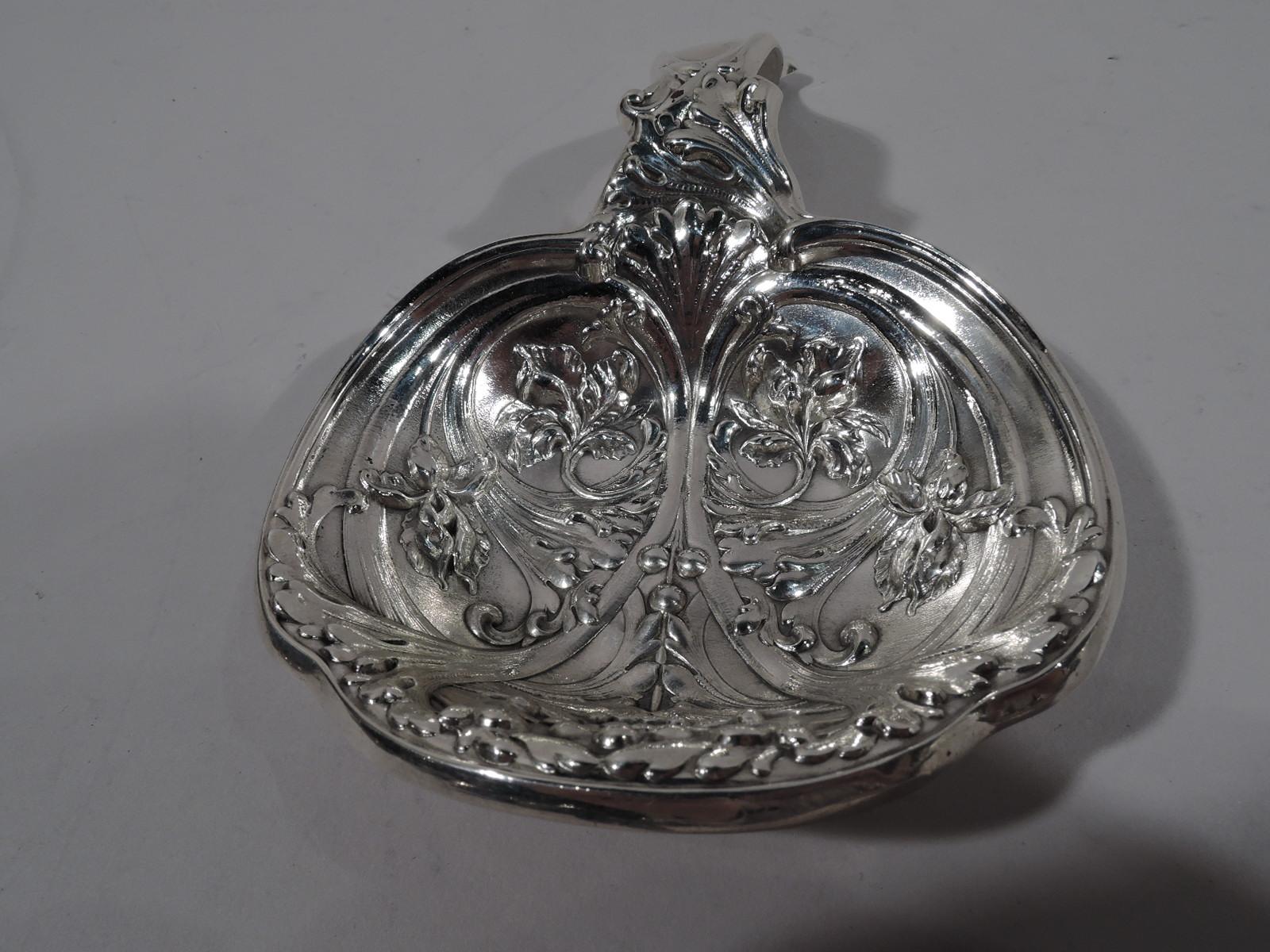Turn-of-the-century Art Nouveau sterling silver bonbon scoop. Made by Gorham in Providence. Round shaped bowl with arched handle. Dynamic ornament with swooshing and colliding leafy scrolls. Fully marked and numbered A4224. Weight: 4.5 troy ounces.