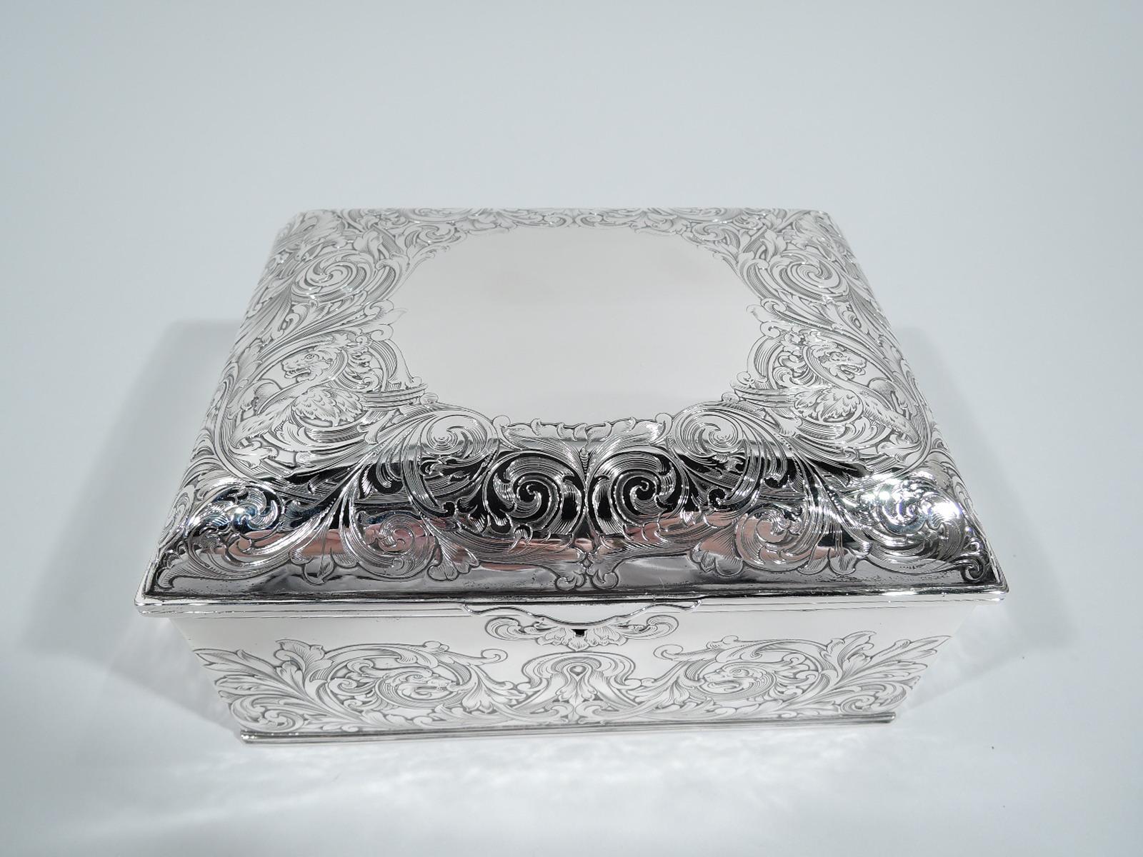 Turn-of-the-century Art Nouveau sterling silver jewelry box. Made by Gorham in Providence. Rectangular with straight sides. Cover hinged and curved with scrolled tab. Acid-etched ornament heightened with engraving: Lush and fluid rinceaux with