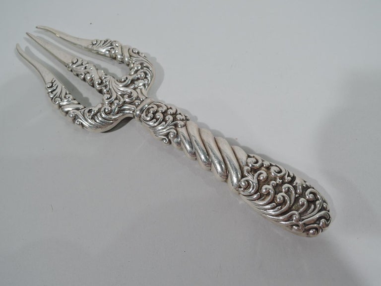 Art Nouveau sterling silver toasting fork. Made by Gorham in Providence, ca 1890. Tapering handle and curved shank with 3 tines. Dense overlapping and dynamic scrollwork as well as twisted fluting. Fully marked including maker’s stamp, copyright