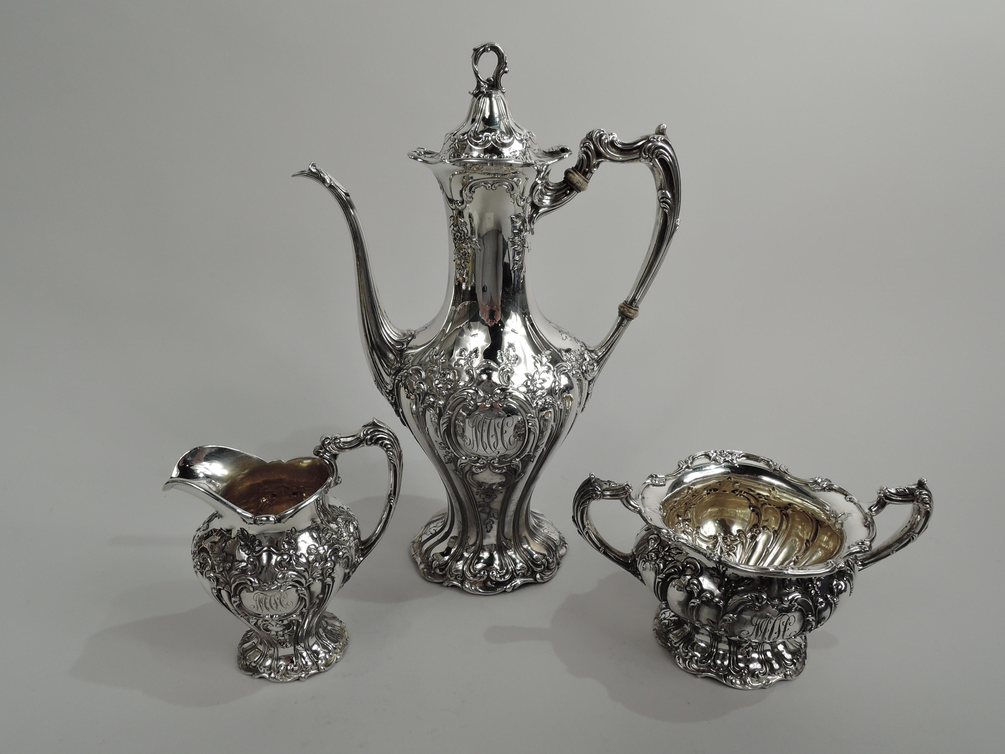Turn-of-the-century Chantilly-Grand sterling silver 3-piece coffee set. Made by Gorham in Providence. This set comprises coffeepot, creamer, and sugar. Scrolled rims, spread and scrolled foot, and reeded and leaf-capped scroll handles. Two scrolled