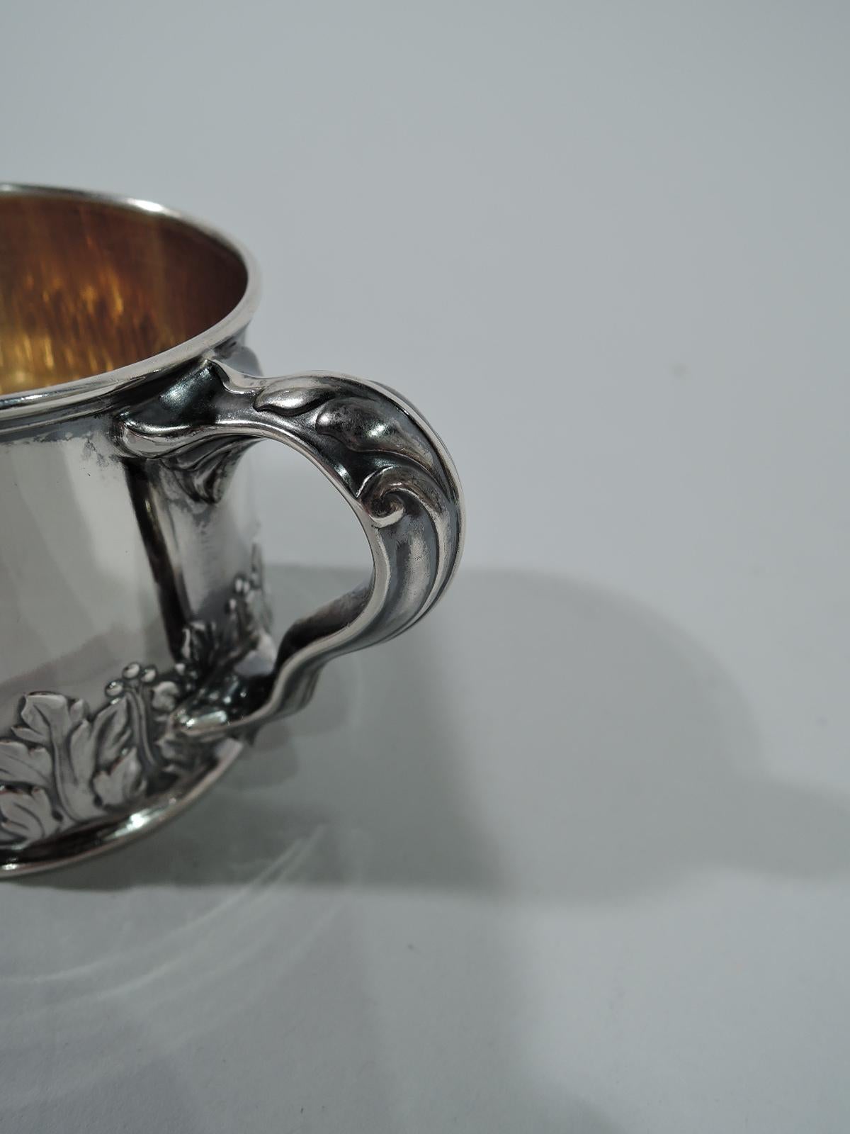 Classical sterling silver baby cup. Made by Gorham in Providence in 1896. Drum-form with leaf-capped scrolled handle. Chased leaf-and-dart border at bottom with lots of room leftover for engraving. Gilt interior. Hallmark includes no. 5230 and date