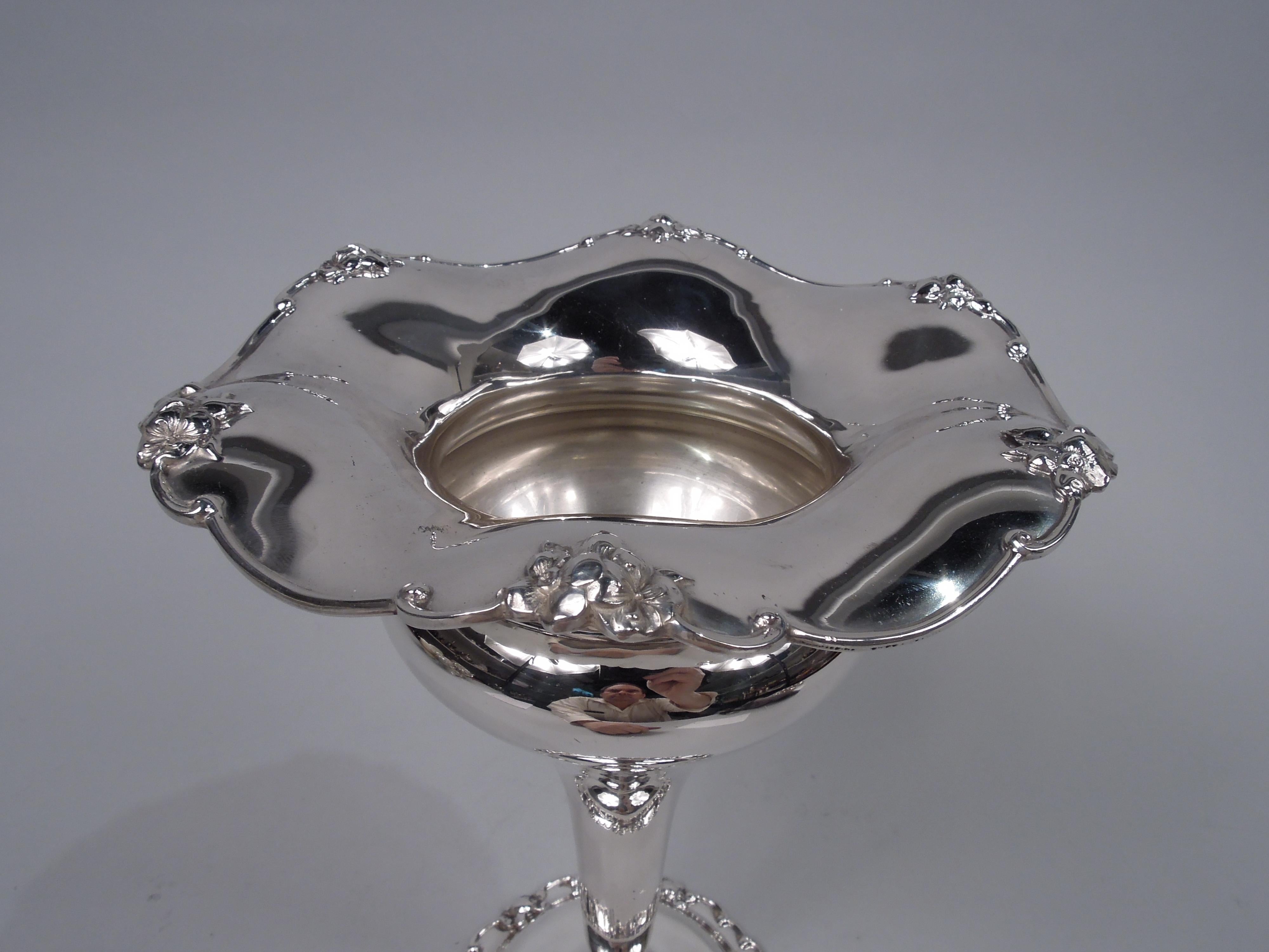 Edwardian sterling silver vase. Made by Gorham in Providence in 1904. Steeply tapering ovoid body; domed foot. Rims scrolled with applied flowers; mouth rim wavy. Fully marked including maker’s stamp, no. 4678A, and date symbol. Weight: 14 troy