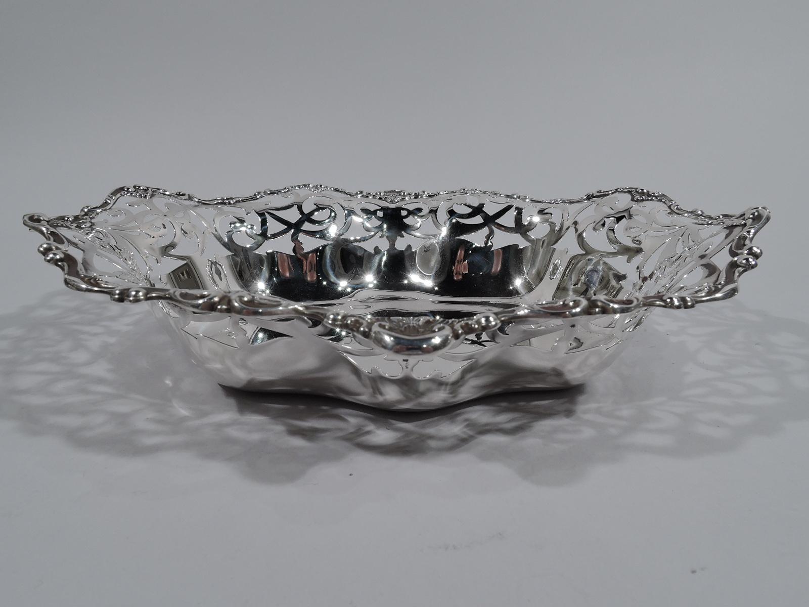Edwardian Classical sterling silver bowl. Made by Gorham in Providence in 1906. Shaped and solid ovalish well. Sides have pierced and interlaced scrollwork. Wavy rim with applied scrolls and leaves. Fully marked including no. A4748 and date symbol.