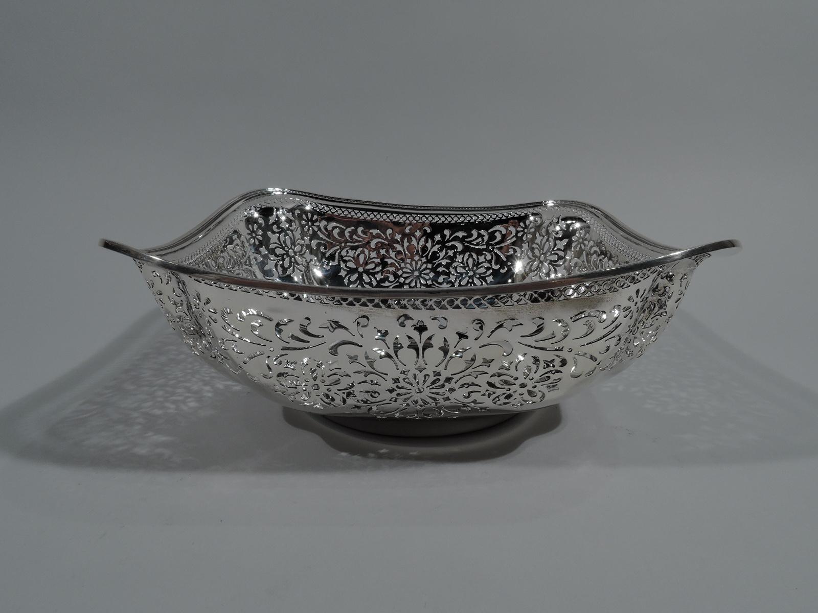 Edwardian sterling silver bowl. Made by Gorham in Providence in 1909. Squarish with circular well, curved sides, wavy rim, and concave corners. Sides have pierced and stylized flowers and leaves, and guilloche border. Hallmark incudes date symbol