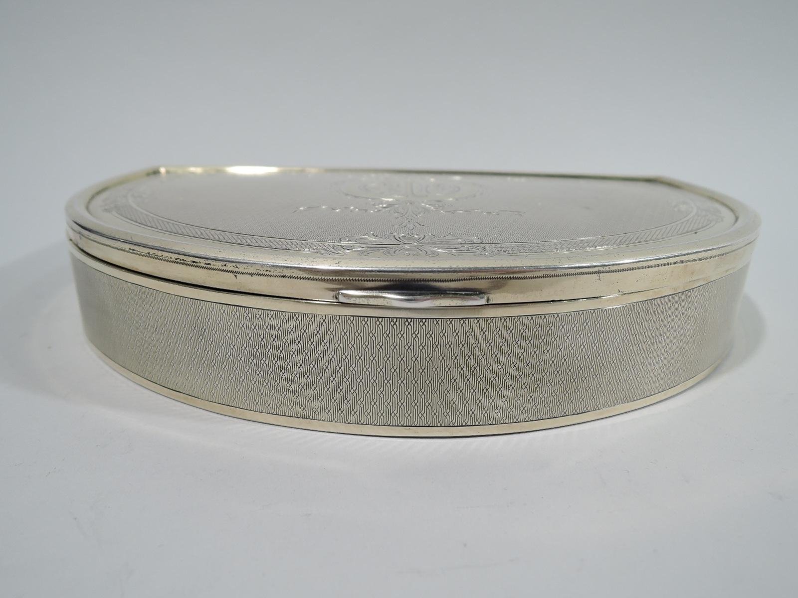 Edwardian Regency gilt sterling silver box. Made by Gorham in Providence in 1917. Lunette-form with flat and hinged cover. Engine-turned wave ornament. Cover ornament includes garland and leaf and ribbon wreath engraved with monogram. Interior has