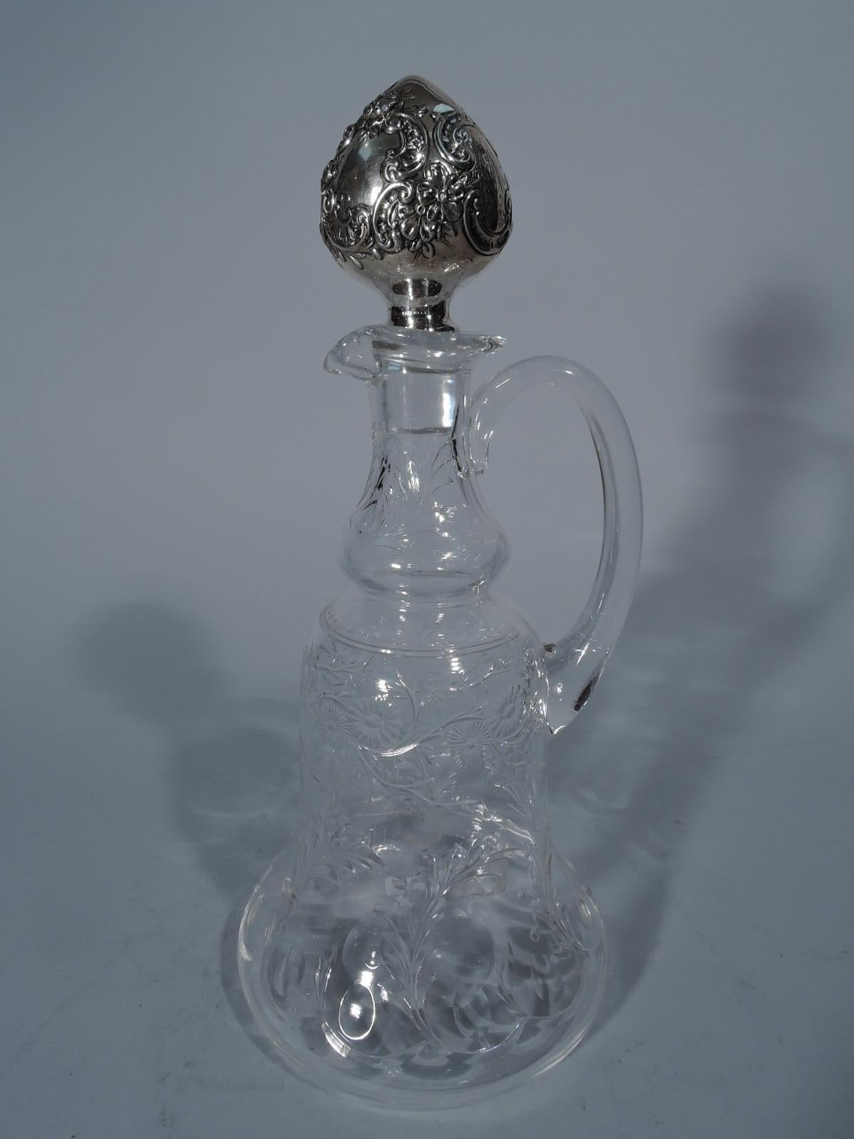 Edwardian crystal decanter with sterling silver stopper. Made by Gorham in Providence in 1897. Bell-form bowl with baluster neck, U-form spout, and c-scroll handle. Engraved and acid-etched flowers and leaves. Stopper ovoid with scrolls and flowers.