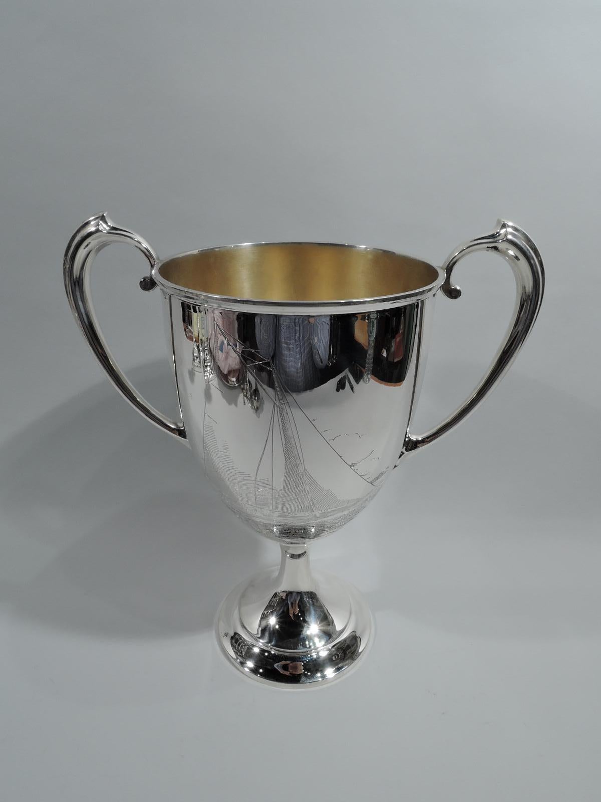 Edwardian Neoclassical sterling silver trophy cup. Made by Gorham in Providence. Oval bowl with high-looping handles and raised foot. Engraved presentation on front: “Inter-Lake Yachting Association / Class Q. Trophy / Presented by / Commodore Emil