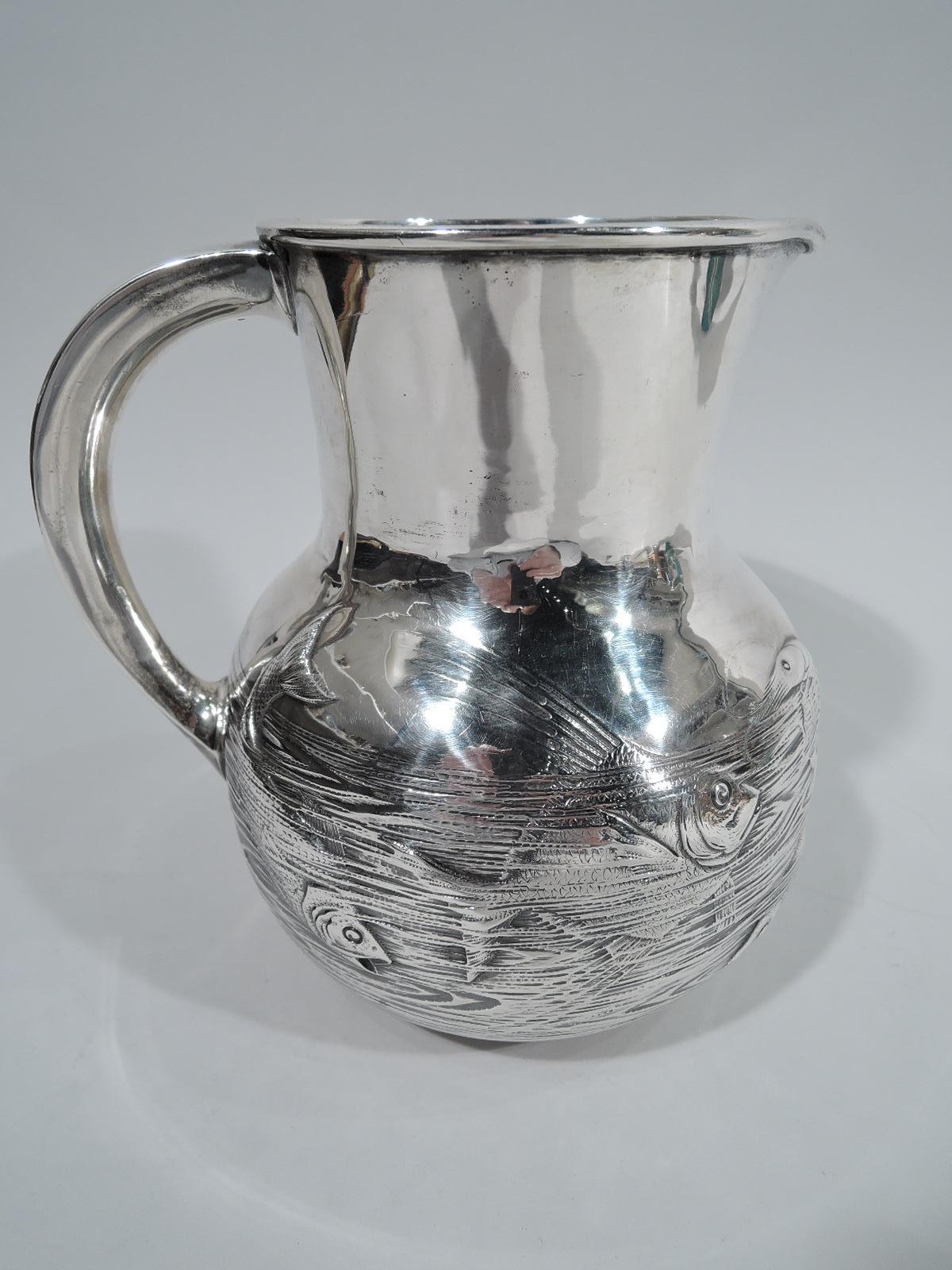 Japonesque sterling silver fishbowl water pitcher. Made by Gorham in Providence in 1883. Drum-form neck with small lip spout and c-scroll handle. Bowl has chased, tooled, and engraved frieze depicting fish gliding and diving and coming up for air.