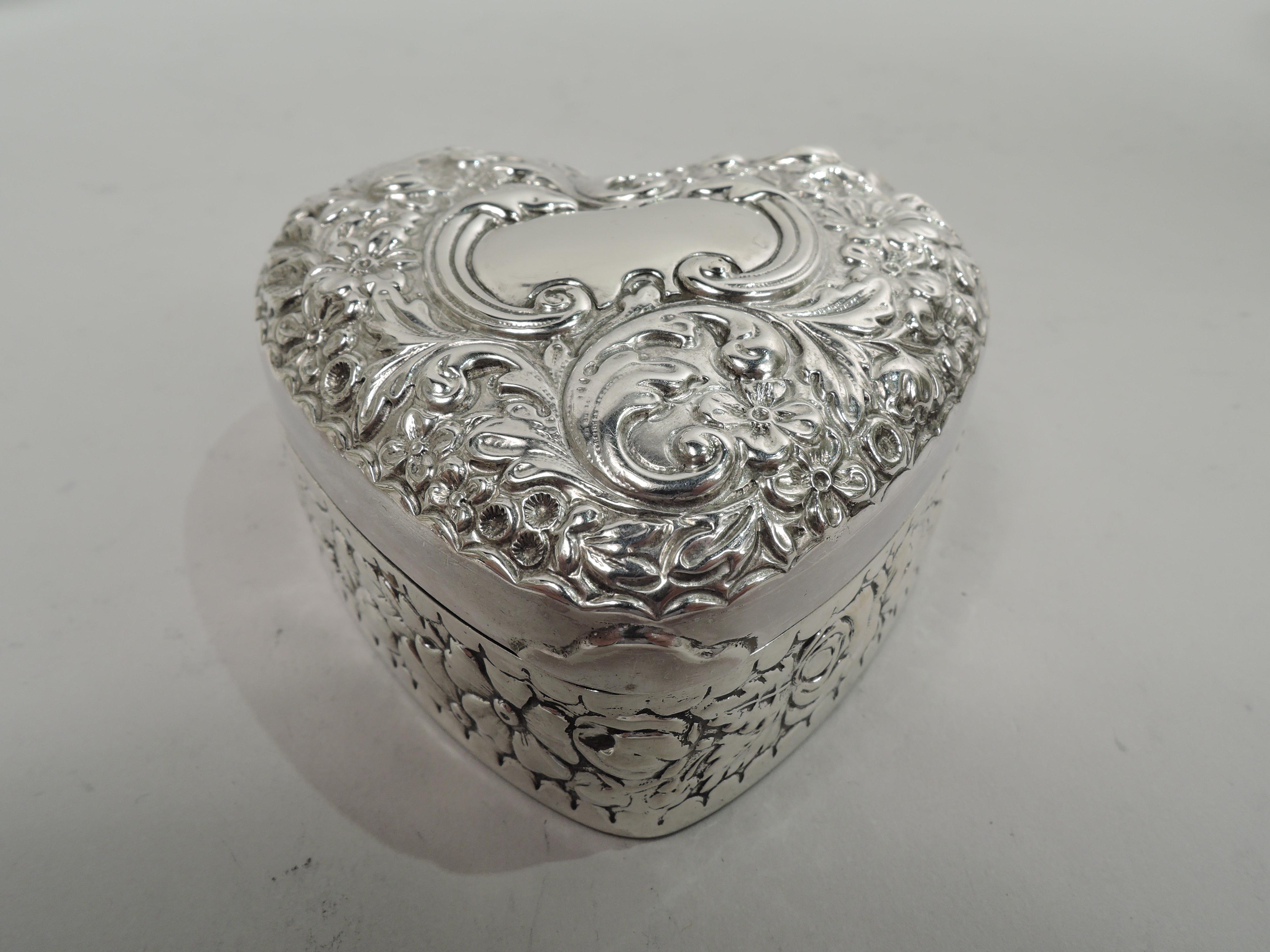 Victorian sterling silver jewelry box. Made by Gorham in Providence, ca 1890. Heart-shaped with dense repousse flowers and scrolls between scalloped borders on sides and cover top. Cover top has scrolled cartouche (vacant). Velvet lined. Fully