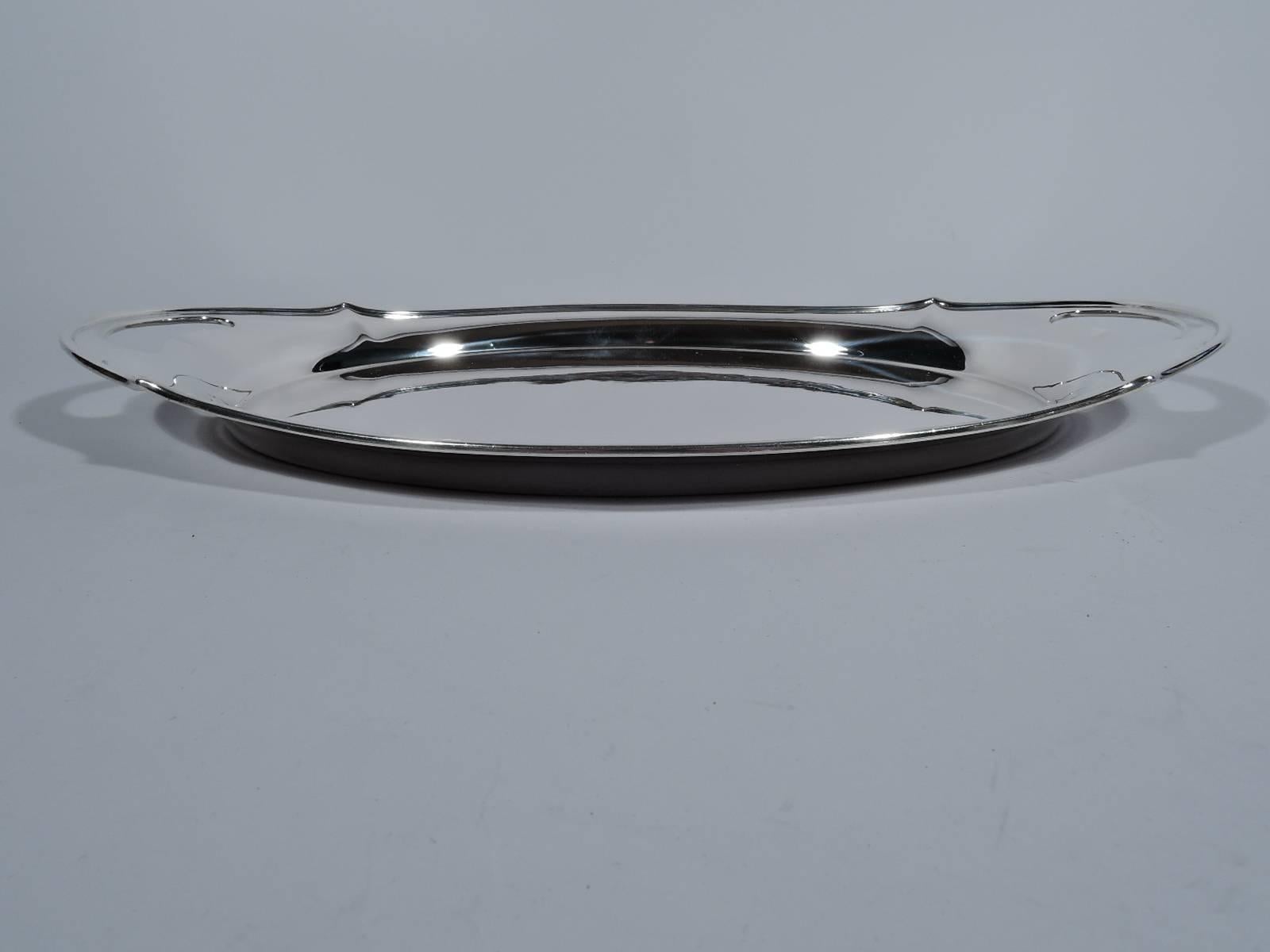 Sterling silver serving tray in Plymouth pattern. Made by Gorham in Providence in 1910. Oval well, tapering sides, and shaped rim. Cut-out kidney handles at ends. Perfect for a drinks party. Hallmark includes date symbol, no. A4609, and retailer’s