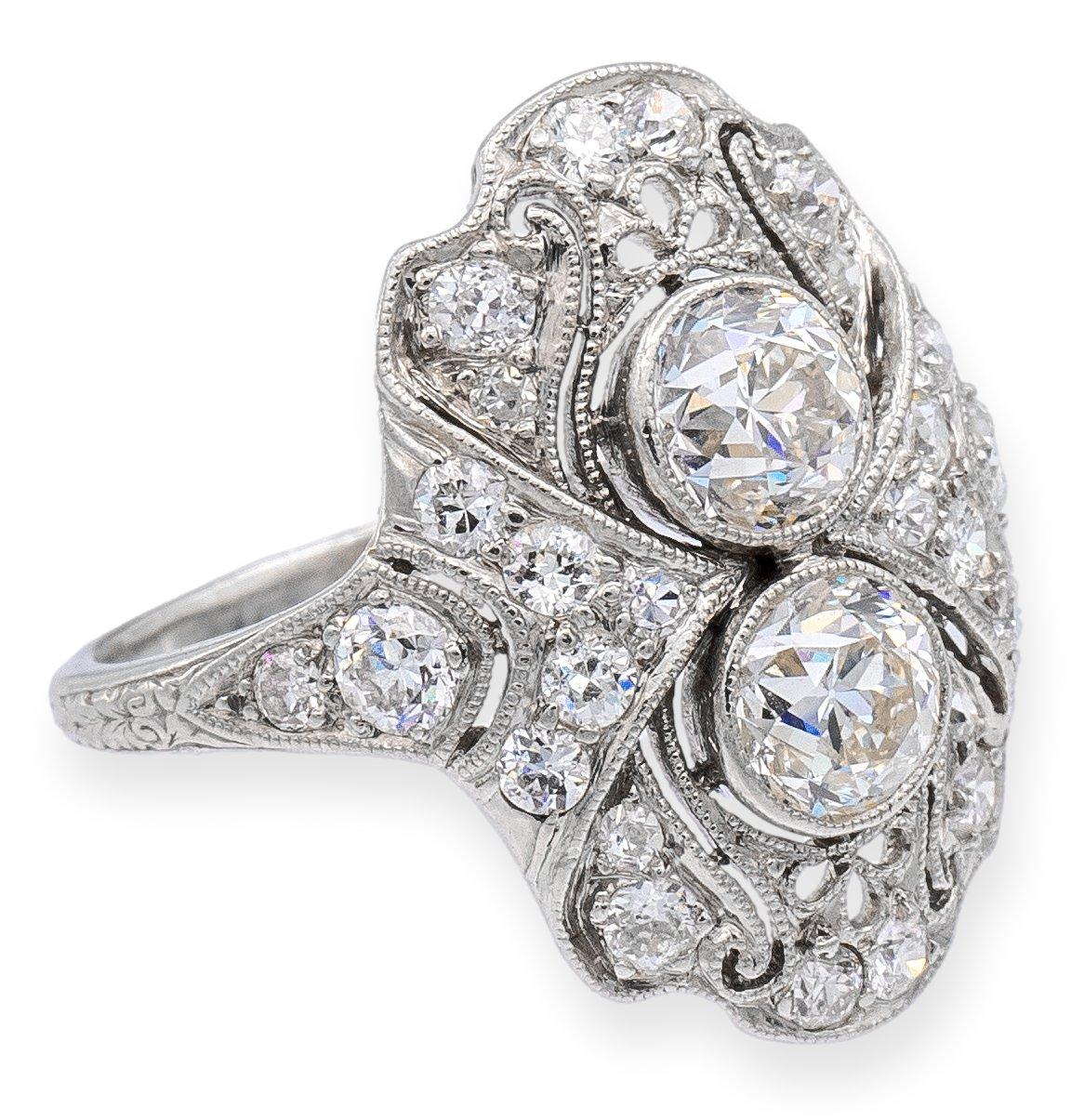 Antique diamond ring associated with the Gorham brand finely crafted in platinum featuring two center Old European cut diamonds set in bezels that weigh 1.20 carats with a color grade of G-H, or near-colorless color and VS clarity. An additional .75