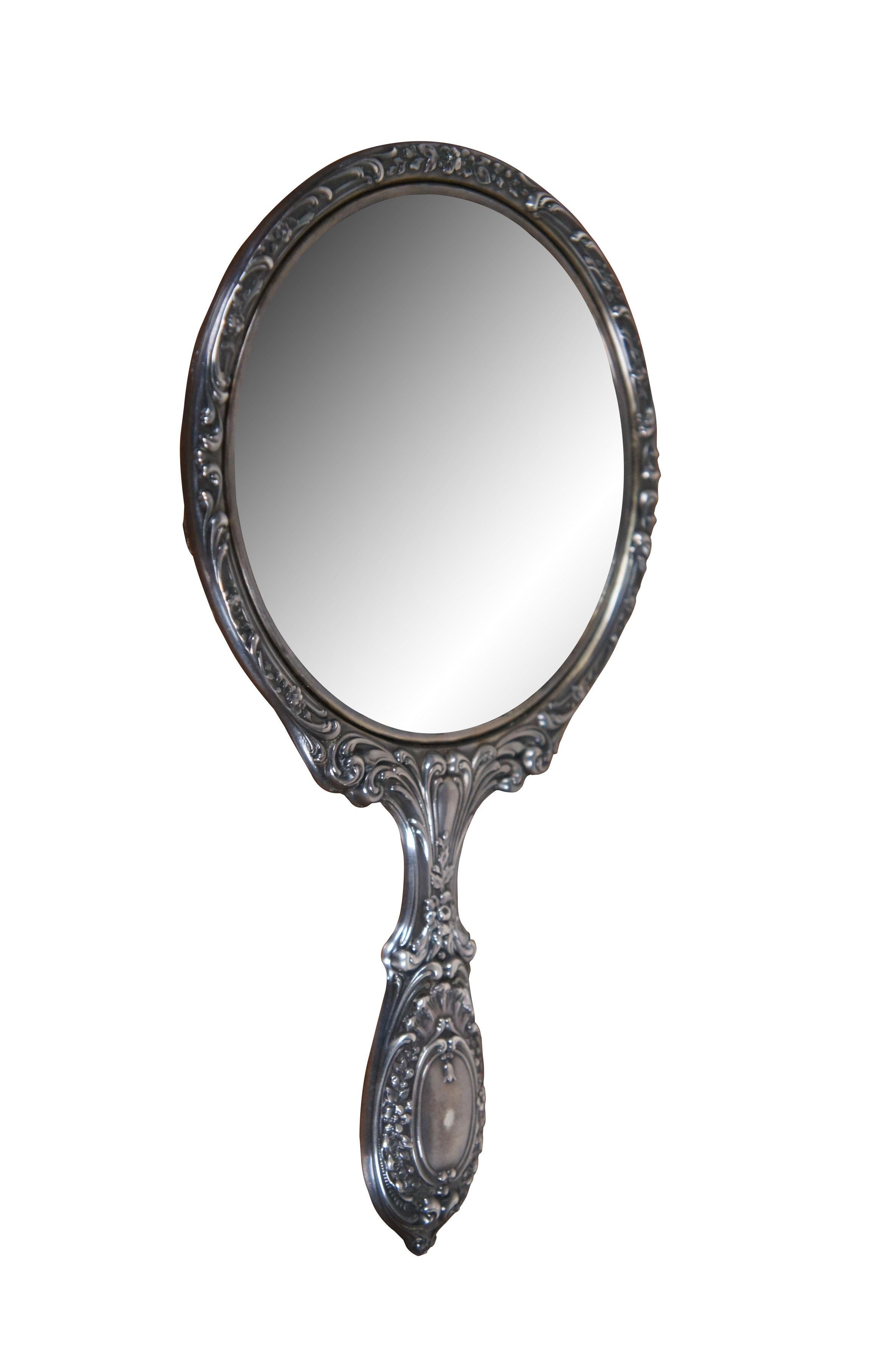 Early 20th century Gorham sterling silver, round hand mirror, number 23, Buttercup pattern featuring a repousse silver frame emblaxoned with scrolling foliates, roses and buttercups around two shield shaped spots perfect for engraving a