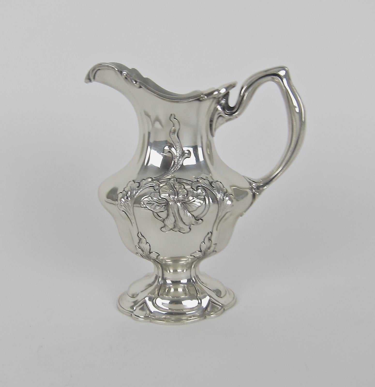 An American antique sterling silver creamer in the Art Nouveau style from Gorham Manufacturing Company of Providence, Rhode Island. The elegant Art Nouveau milk or cream pitcher rests on a spreading lobed foot and the body is decorated with delicate