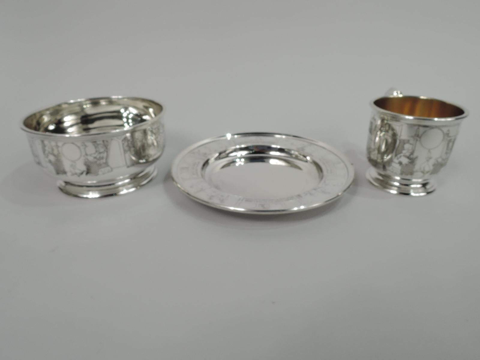 Turn-of-the-century Edwardian sterling silver baby set. Made by Gorham in Providence. This set comprises cup, bowl, and plate. Cup has scroll bracket handle, raised and stepped foot, and gilt interior. Bowl has same foot. Plate has deep well.