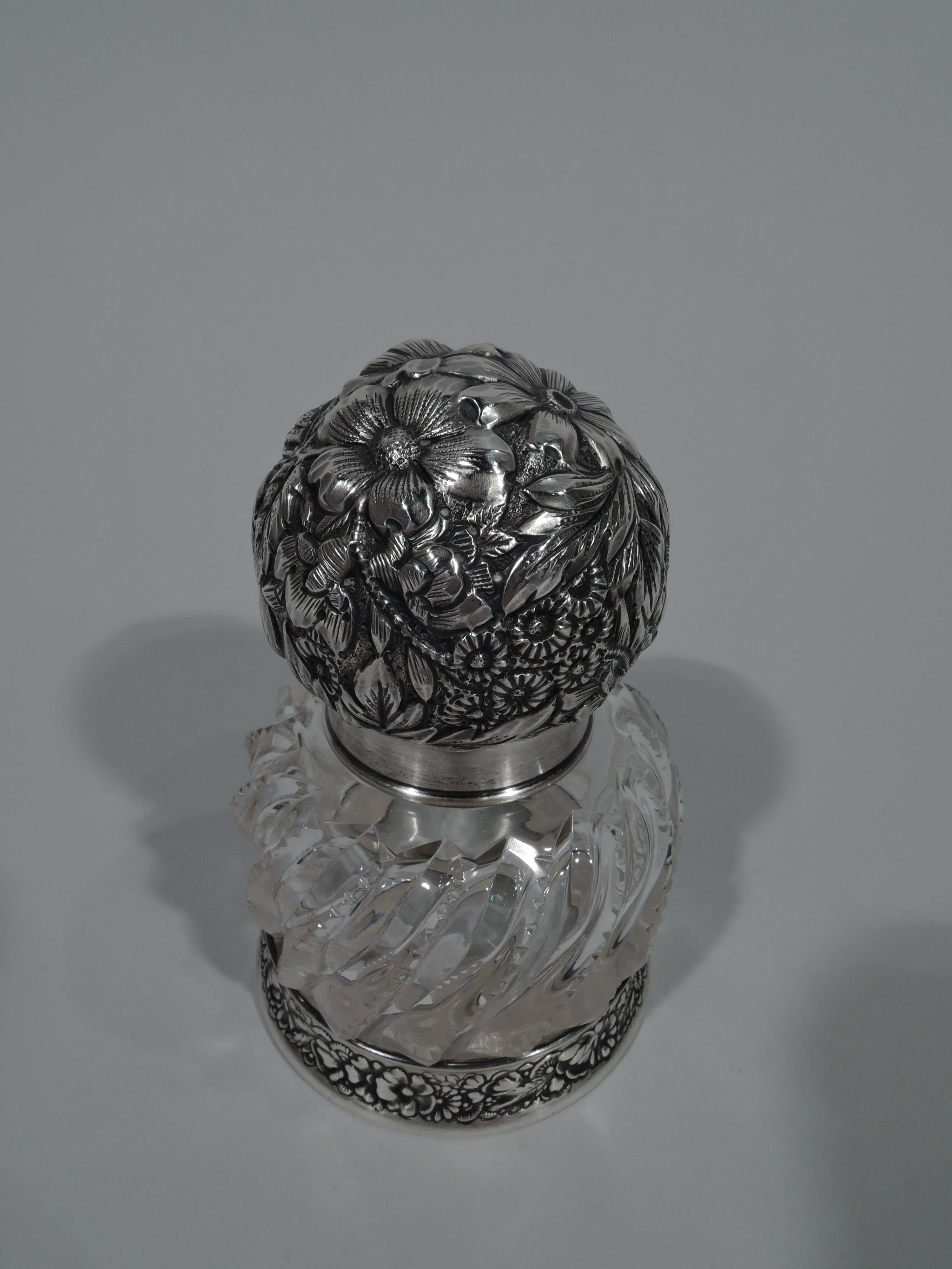 Victorian sterling silver and glass inkwell. Made by Gorham in Providence in 1889. Drum form with curved shoulder and zipper-cut twisted flutes. Short neck with sterling silver collar and hinged ball cover with allover floral repousse. Sterling
