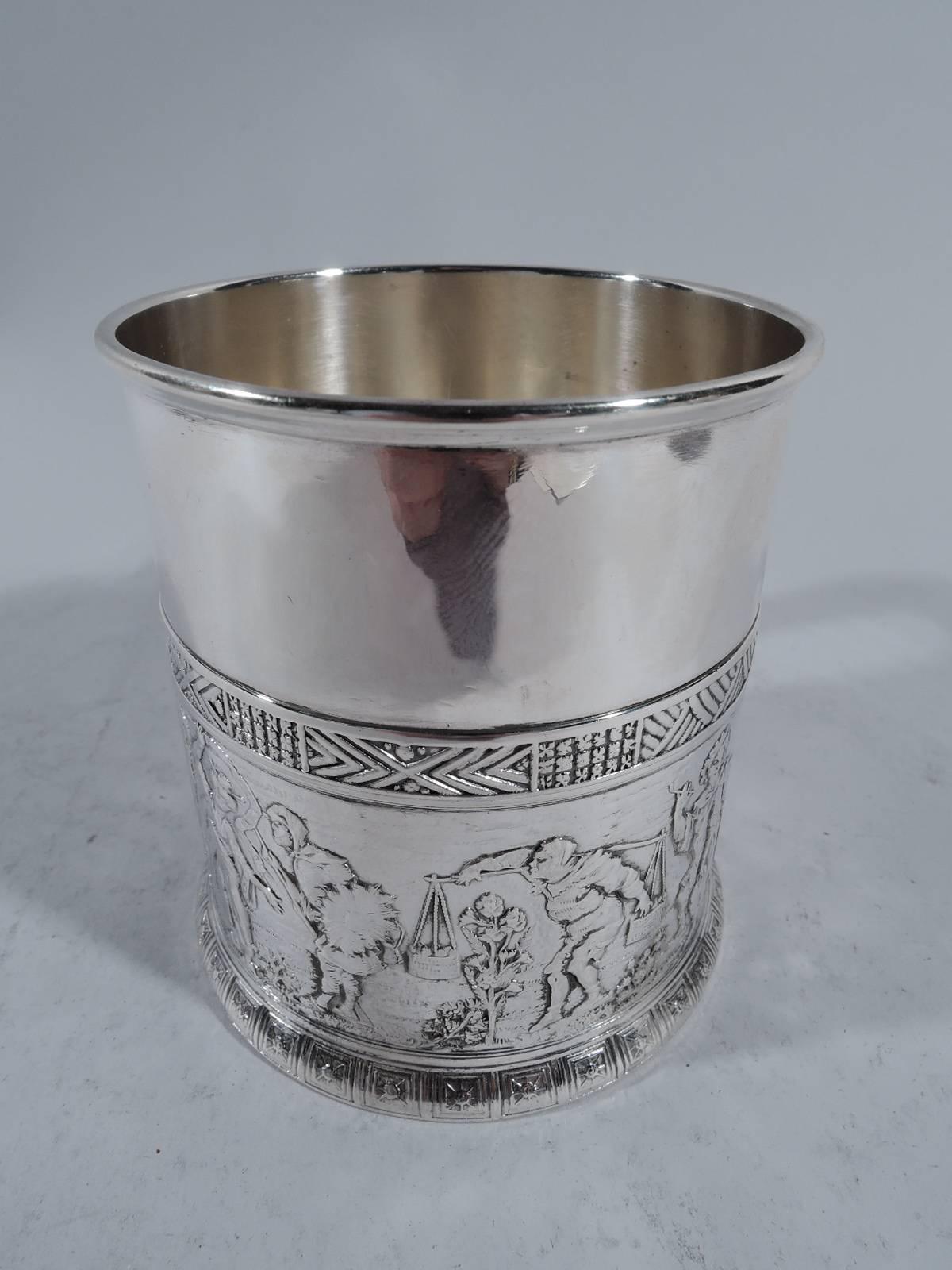 Sterling silver baby cup. Made by Gorham in Providence in 1882. Straight and gently upward tapering sides and bracket handle with reeded bands. Low-relief frieze with exotic personages including a dancer, axman, sandal-shod indigene, and kimono-clad