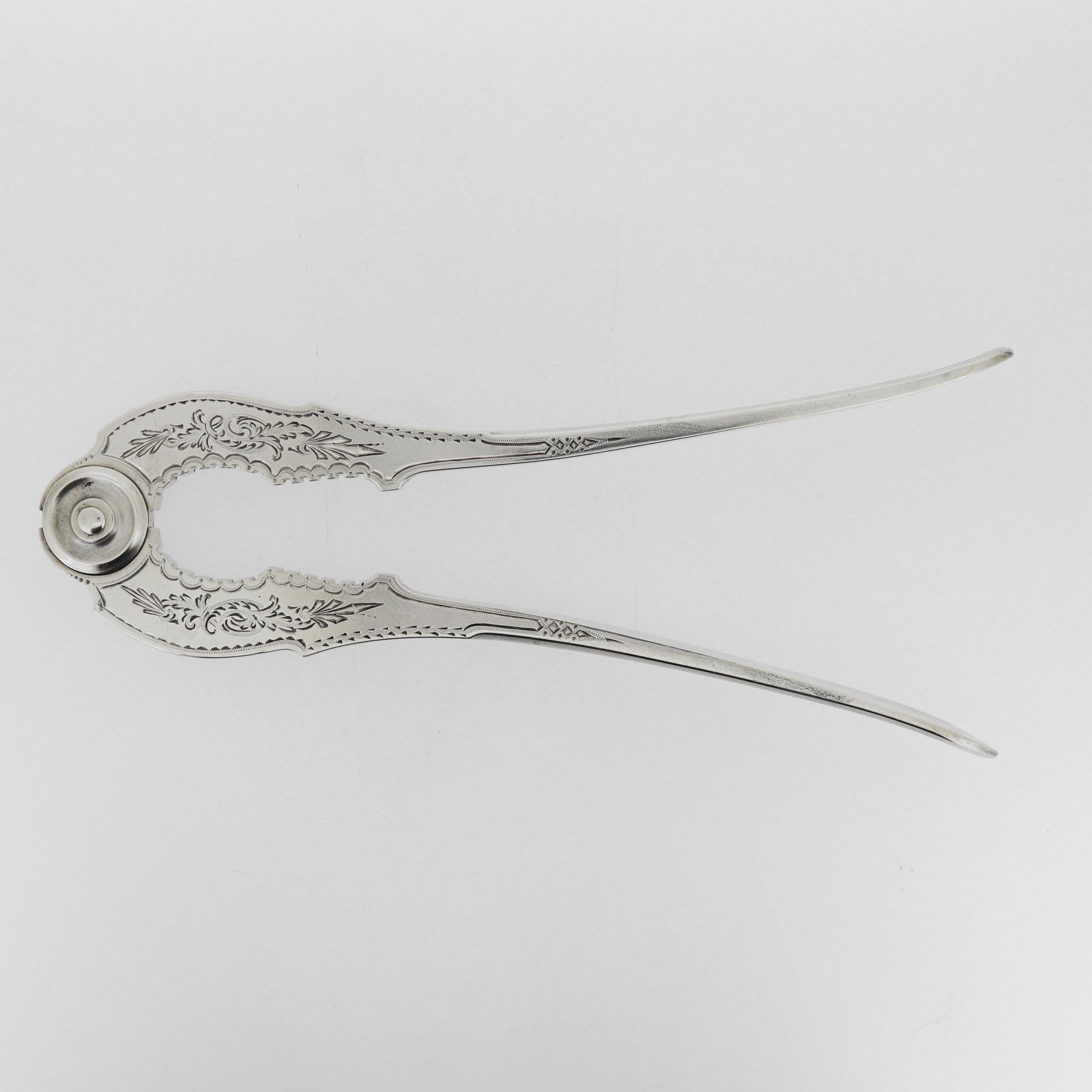 Un raffinato e antico rompigranella o rompi conchiglia d'argento americano.

Da Gorham Manufacturing Co.

In argento sterling.

Con motivi floreali tagliati al brite e dispositivi geometrici su ciascun lato.

Semplicemente un meraviglioso cracker
