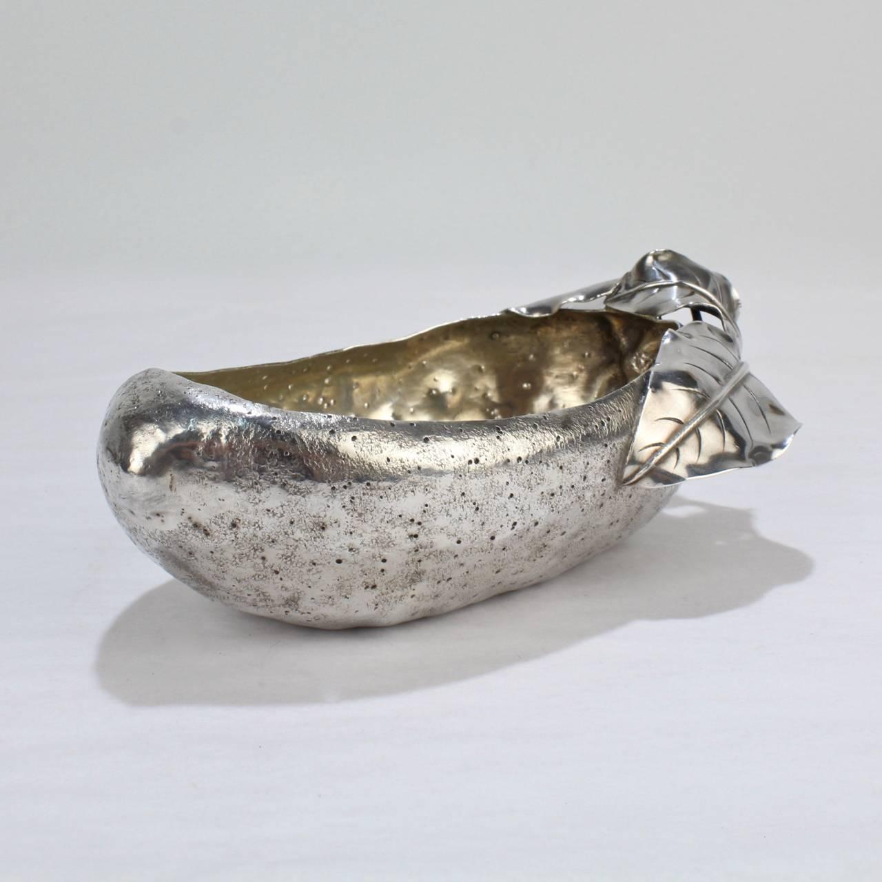 A wonderful, figural antique Gorham sterling silver Olive bowl.

In the form of a large olive with a 'twig and leaves' handle and a mottled and spotted surface. There are traces of the original gilding to the interior of the bowl.

The base is