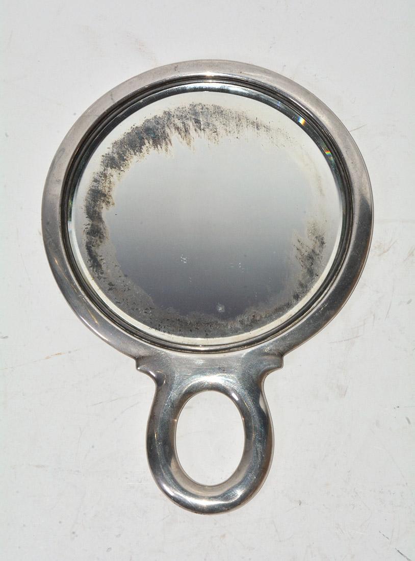 The antique hand mirror is stamped 