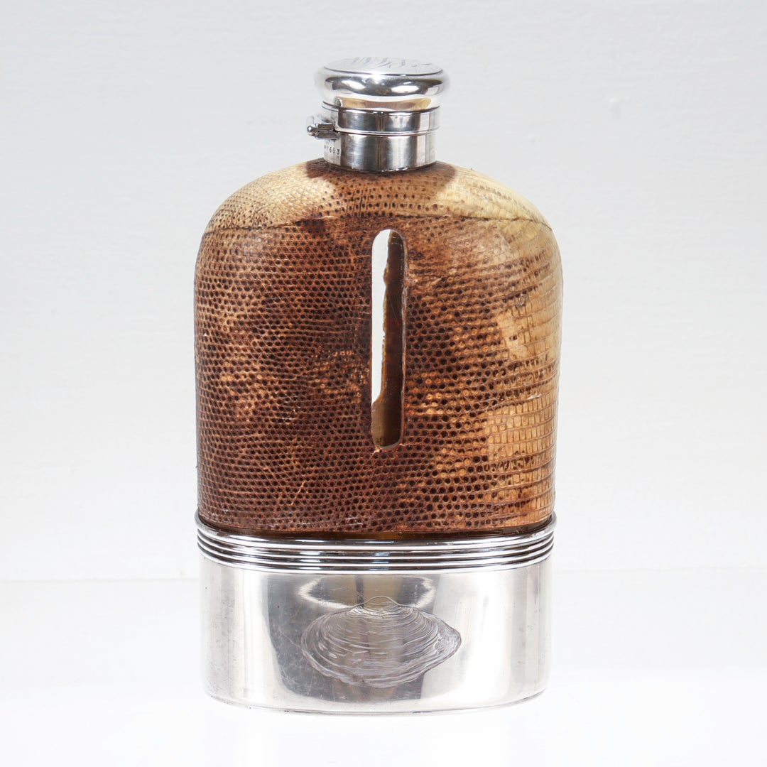 A very fine antique liquor or whiskey 1 Pint flask.

By Gorham.

With a sterling twist-seal cap and removable cup on a leather covered blown glass body.

The leather cover has window on each side to monitor the content levels, and the cup has a gold
