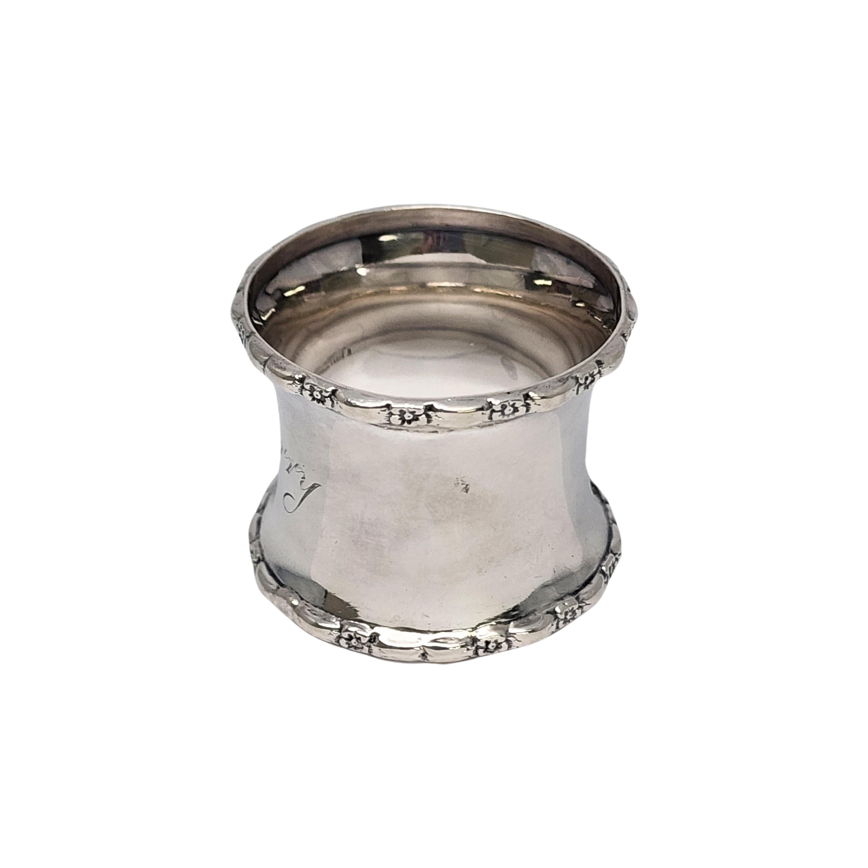 Antique sterling silver napkin ring with engraving by Gorham.

Engraving appears to be 