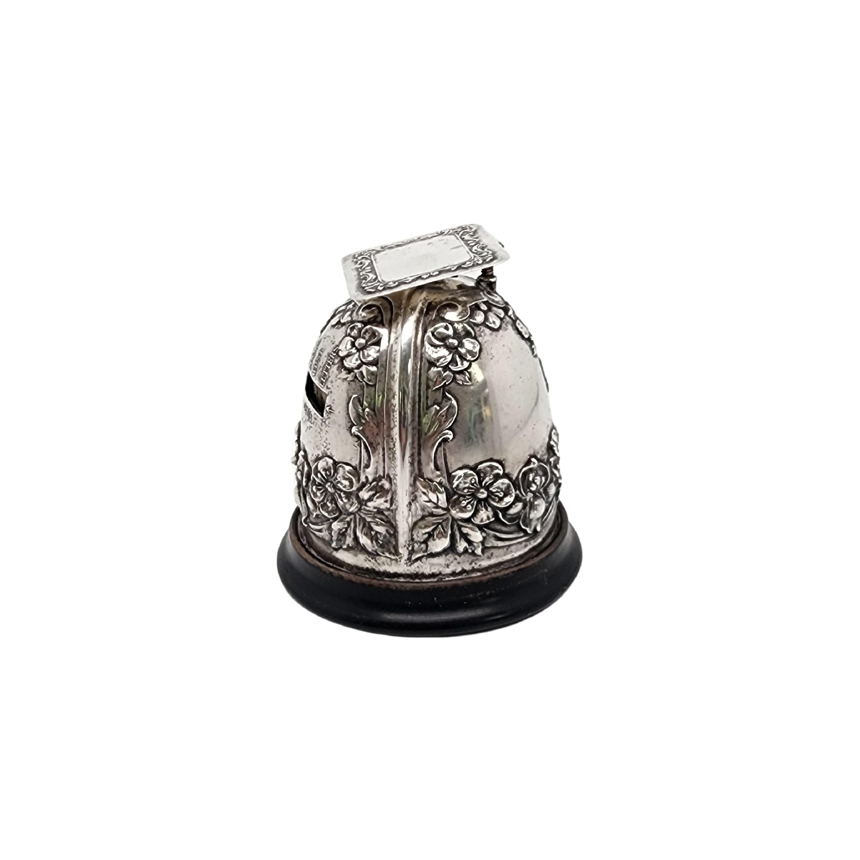 Antique sterling silver postal scale by Gorham, circa 1904.

This antique postal scale features a repousse floral pattern domed scale on a wooden base with a small rectangular platform also adorned in a repousse pattern, screw calibrator. Shipping