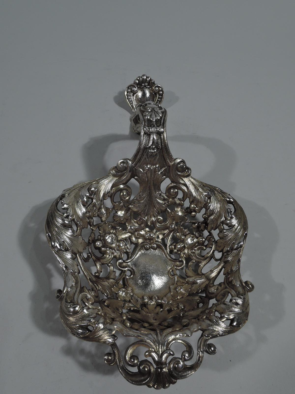 Large and heavy turn-of-the-century sterling silver bonbon scoop. Made by Gorham in Providence. Deep and shaped bowl with central strapwork cartouche surrounded by leaves and flowers. S-scroll handle with shell and scroll terminal. Lightly gilt