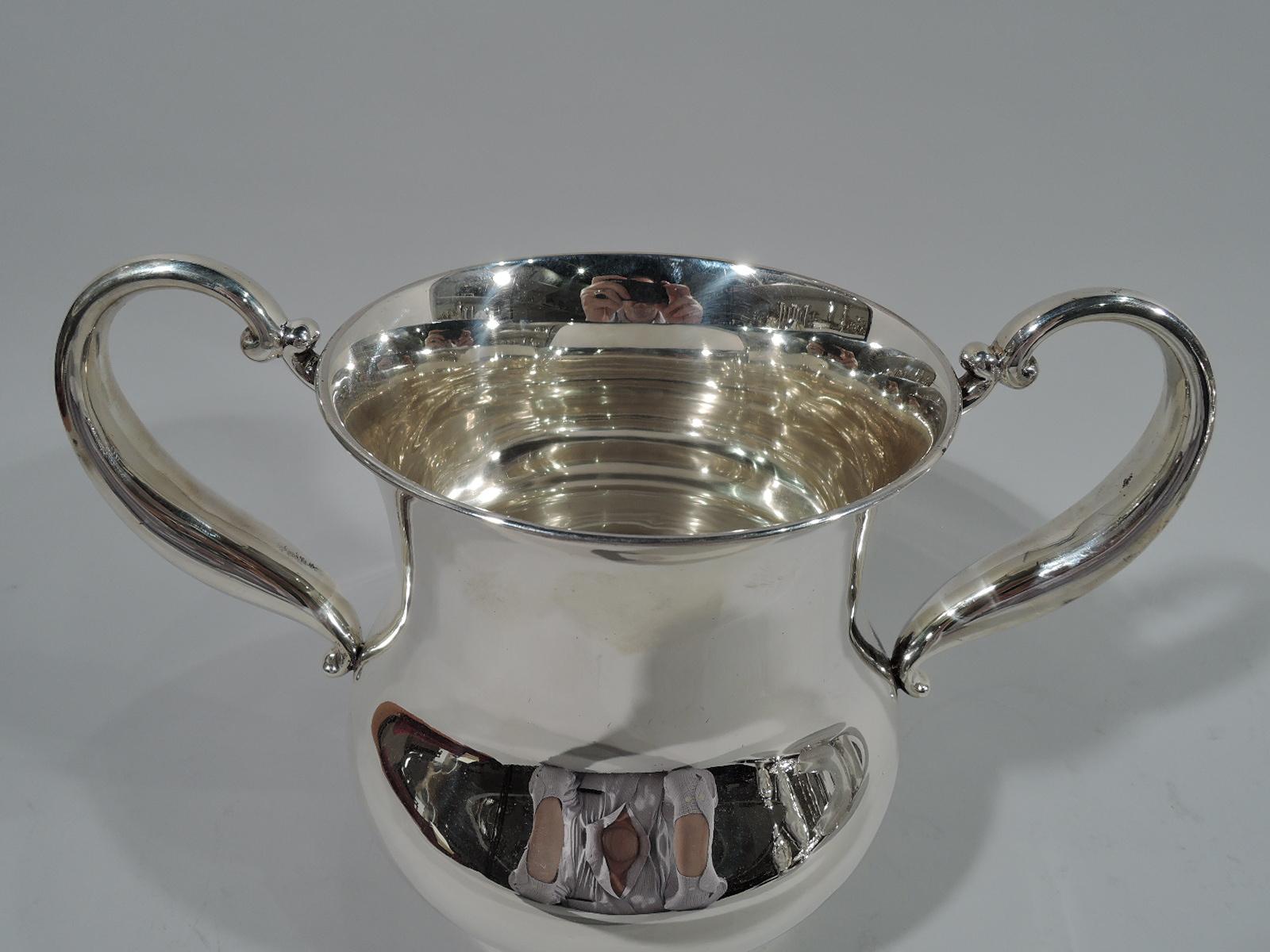Victorian sterling silver trophy cup. Made by Gorham in Providence in 1898. Bellied baluster with tapering s-scroll side handles and stepped foot. Lots of room for engraving. Hallmark includes date symbol, no. A33M, and volume (3 1/2 pts). Weight: