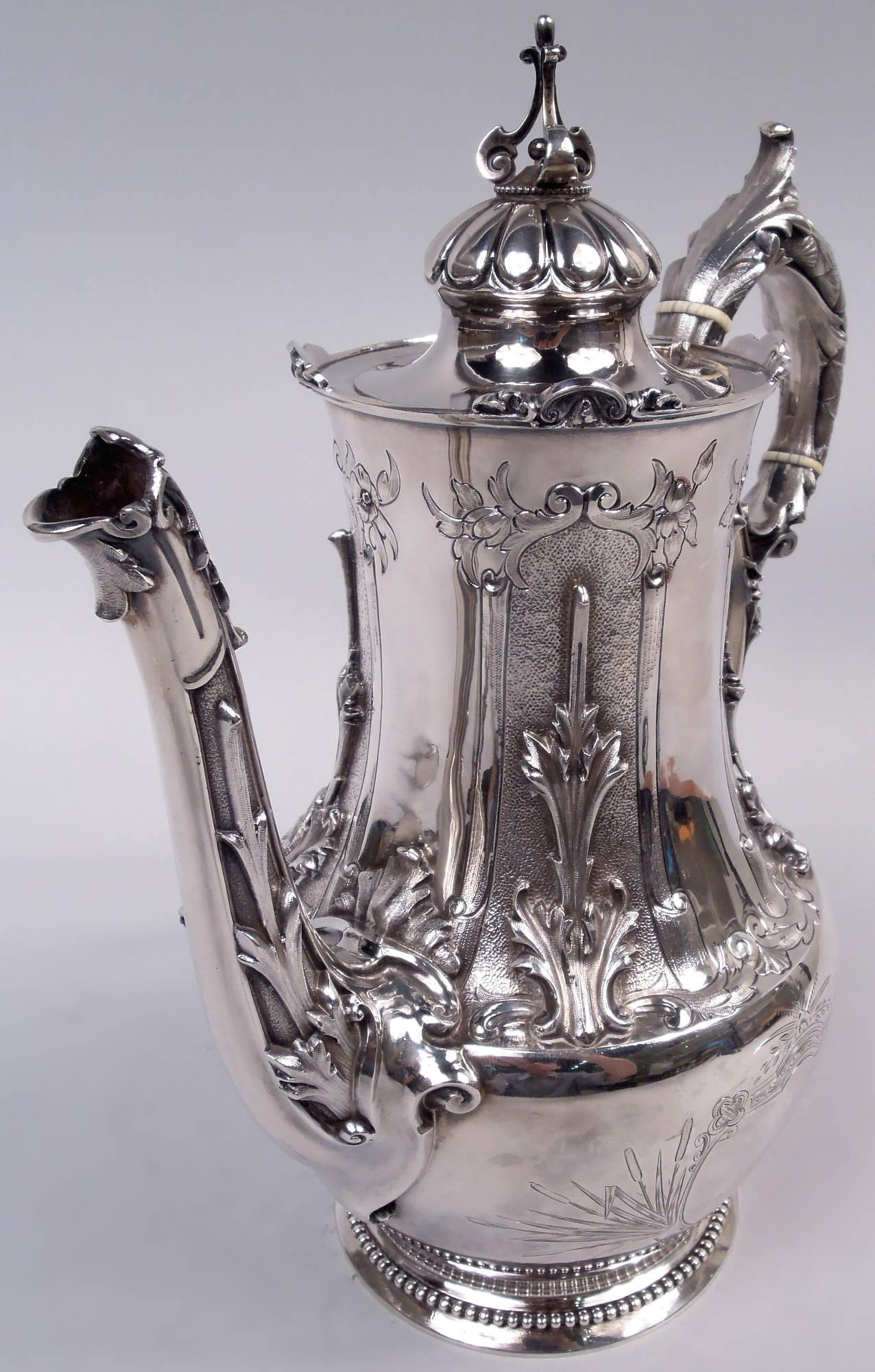 Gothic Classical coin silver coffeepot. Made by Gorham in Providence, ca 1860. Tapering ovoid bowl with tall neck and spread foot. Cover hinged and flush with trefoil finial mounted to lobed dome. High-looping imbricated leaf handle with leaf cap