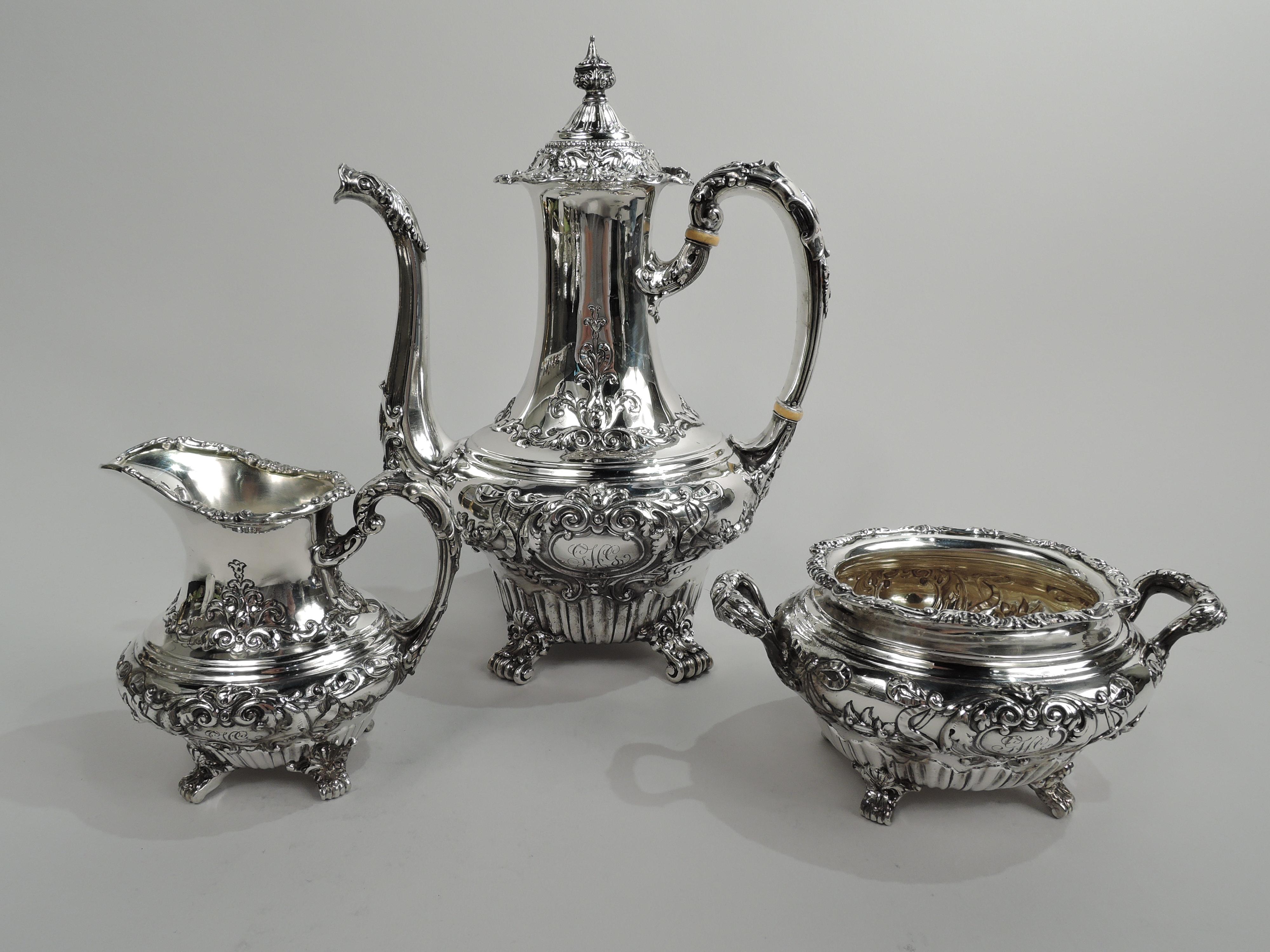 Turn-of-the-century Victorian Rococo sterling silver 3-piece coffee set. Made by Gorham in Providence. This set comprises coffeepot, creamer, and sugar. Bellied with irregular fluting at bottom and leaf and scroll-mounted volute scroll supports