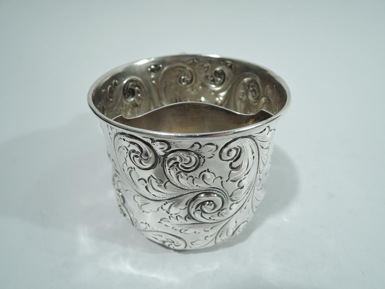 Victorian sterling silver shaving mug. Made by Gorham in Providence in 1892. Straight sides and curved bottom with foot ring. Loose and dynamic leafing scrolls chased and engraved on sides. Leaf-capped scroll handle with bead-and-real applied to