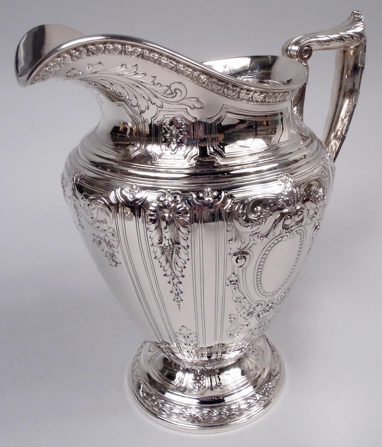 Brocca per acqua in argento sterling Maintenon. Prodotto da Gorham a Providence nel 1929. Corpo ovoidale su piede rialzato; bocca a elmo e maniglia a staffa a voluta con terminale a voluta. Sul corpo, volute di foglie e fiori in cornici curvilinee