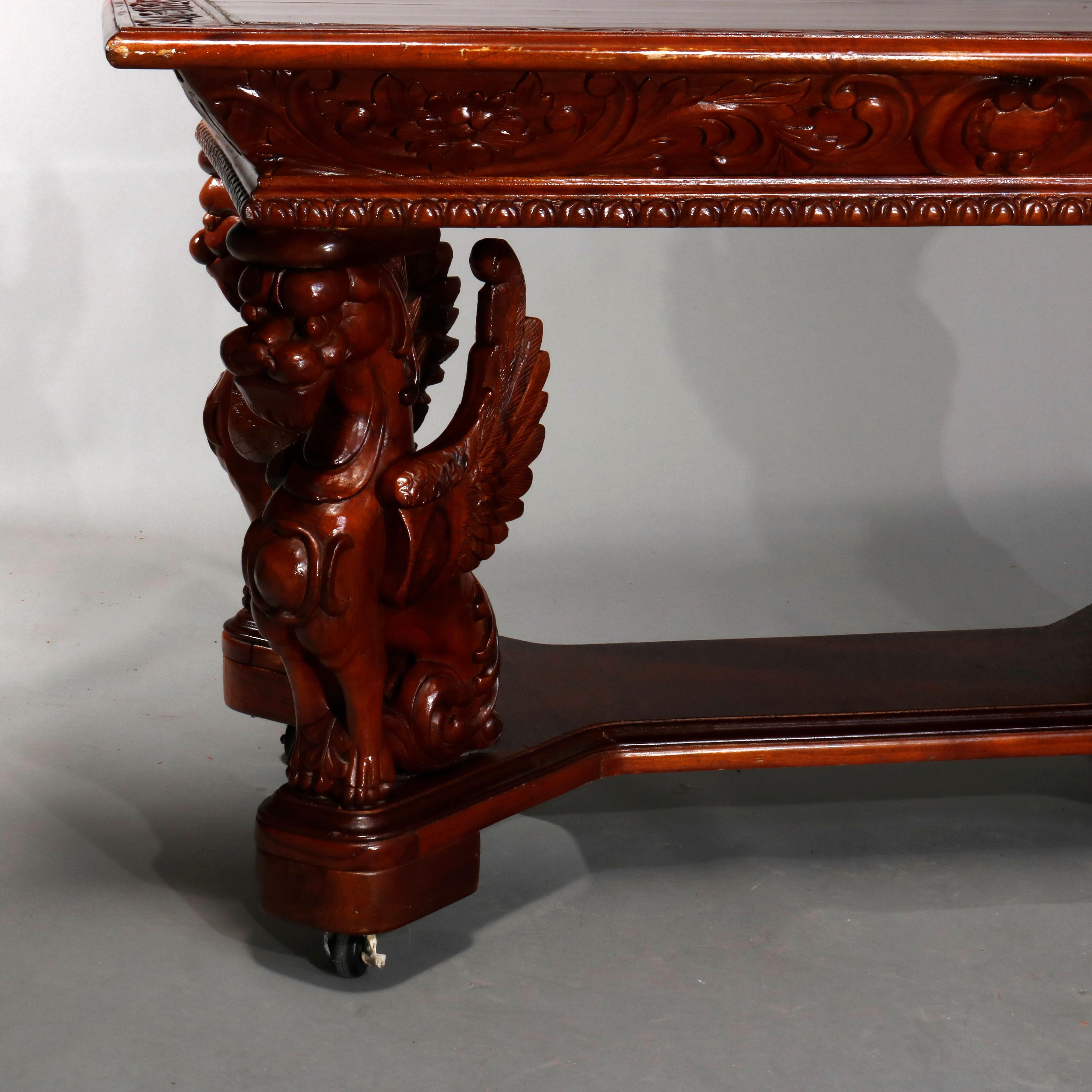 An antique Gothic figural library table offers mahogany construction with top having carved foliate bordering, deep skirt and raised on full sculptural griffin form legs with shaped lower shelf, 20th century
  

Measures: 32
