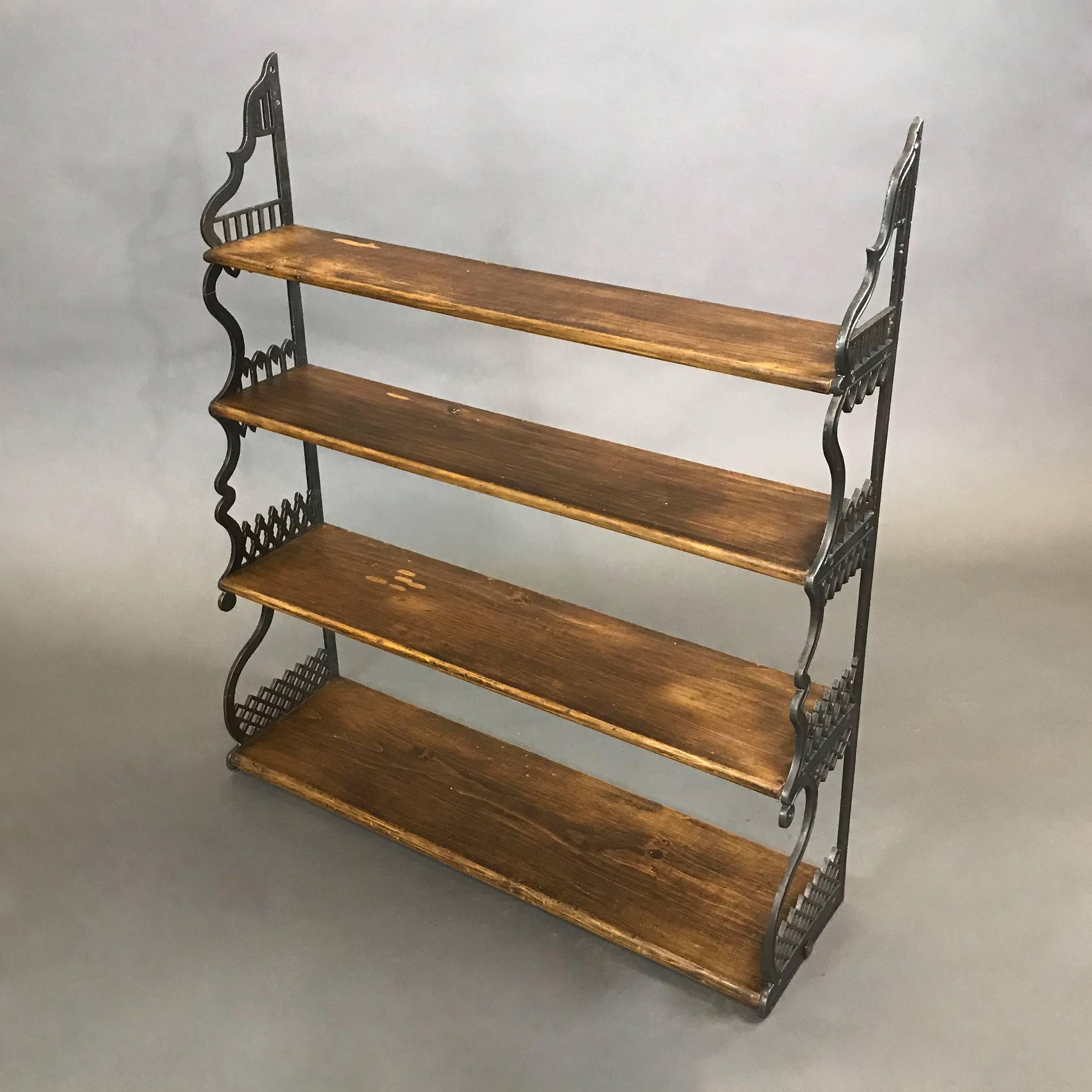 Antique, Gothic, open, wall mount shelf features decorative cast iron braces with oak shelves.