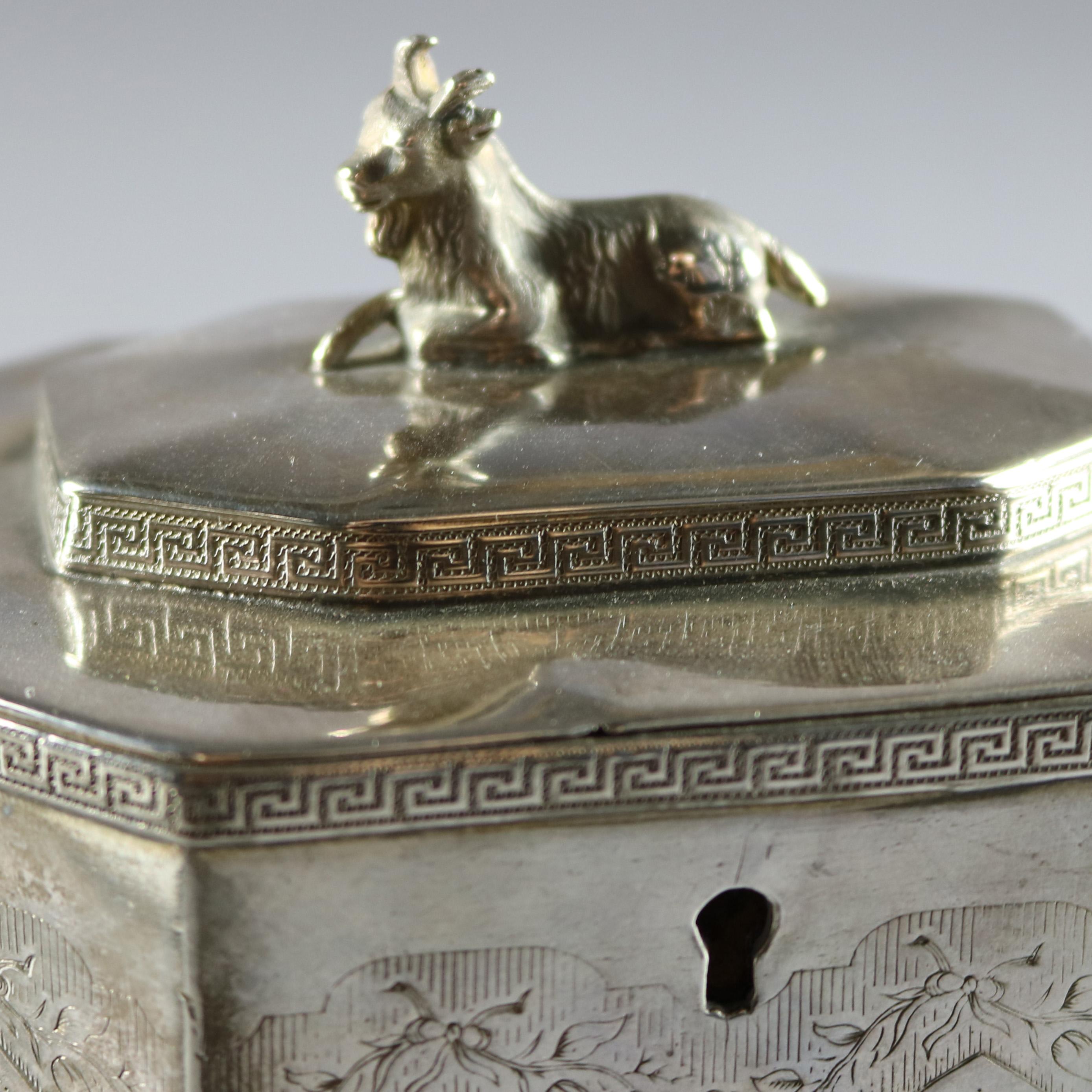 Antique Gothic style reed and barton silver plate tea caddy features hexagonal form with etched panels decorated in arch and foliate with upper and lower Greek key bordering, hinged lid with figural goat finial opens to reveal two internal