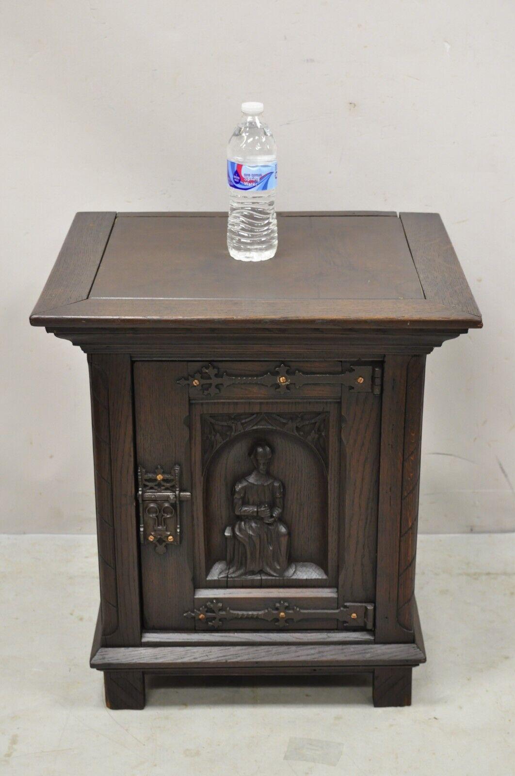 Antique Gothic Renaissance revival oak wood figural carved low cabinet. Item features relief carved figure to door, drape carved wooden sides, inset masonite board top (not original), solid wood construction, beautiful wood grain, nicely carved