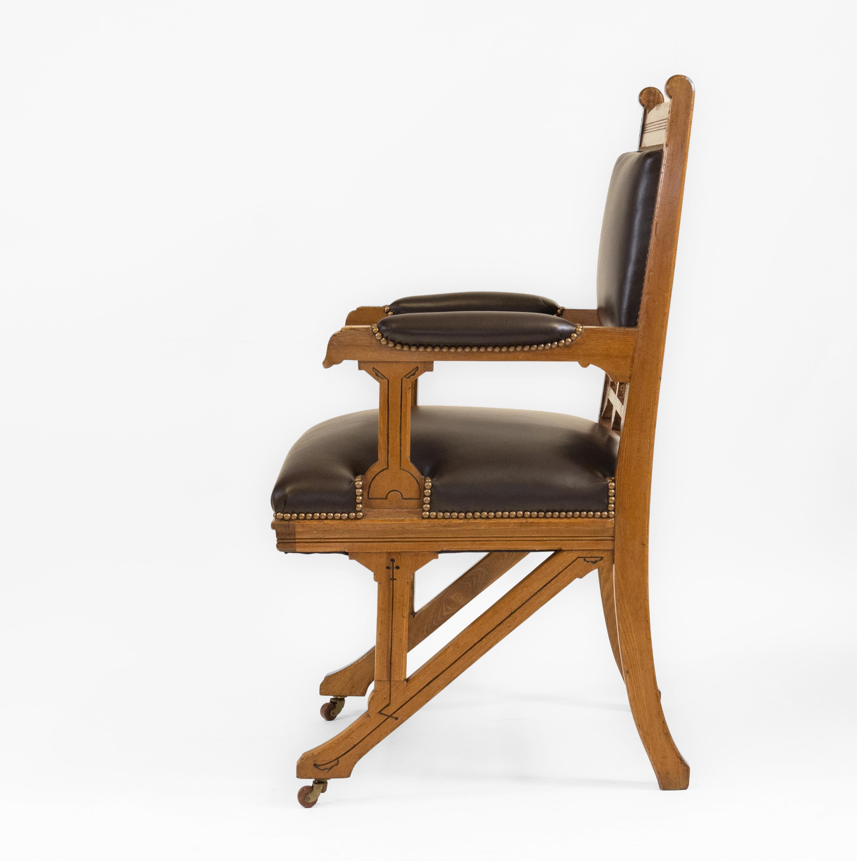 Antique Gothic Revival ash & leather armchair desk chair, sitting on castors. English - Circa 1880.
 
The chair has been fully reupholstered including re-webbing and finished in a quality pigmented dark brown leather by Wildman & Bugby. It has a
